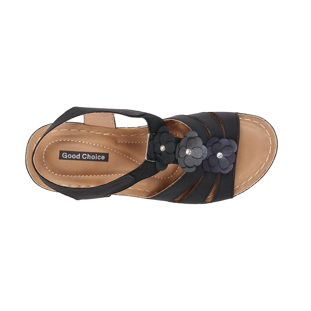 Black sandal with floral details on a white background