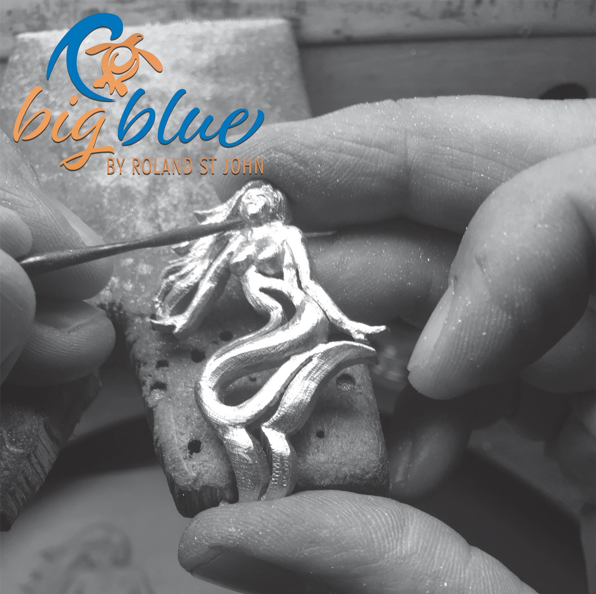 Silver mermaid pendant being worked on with a tool, branded 'big blue by Roland St John'.