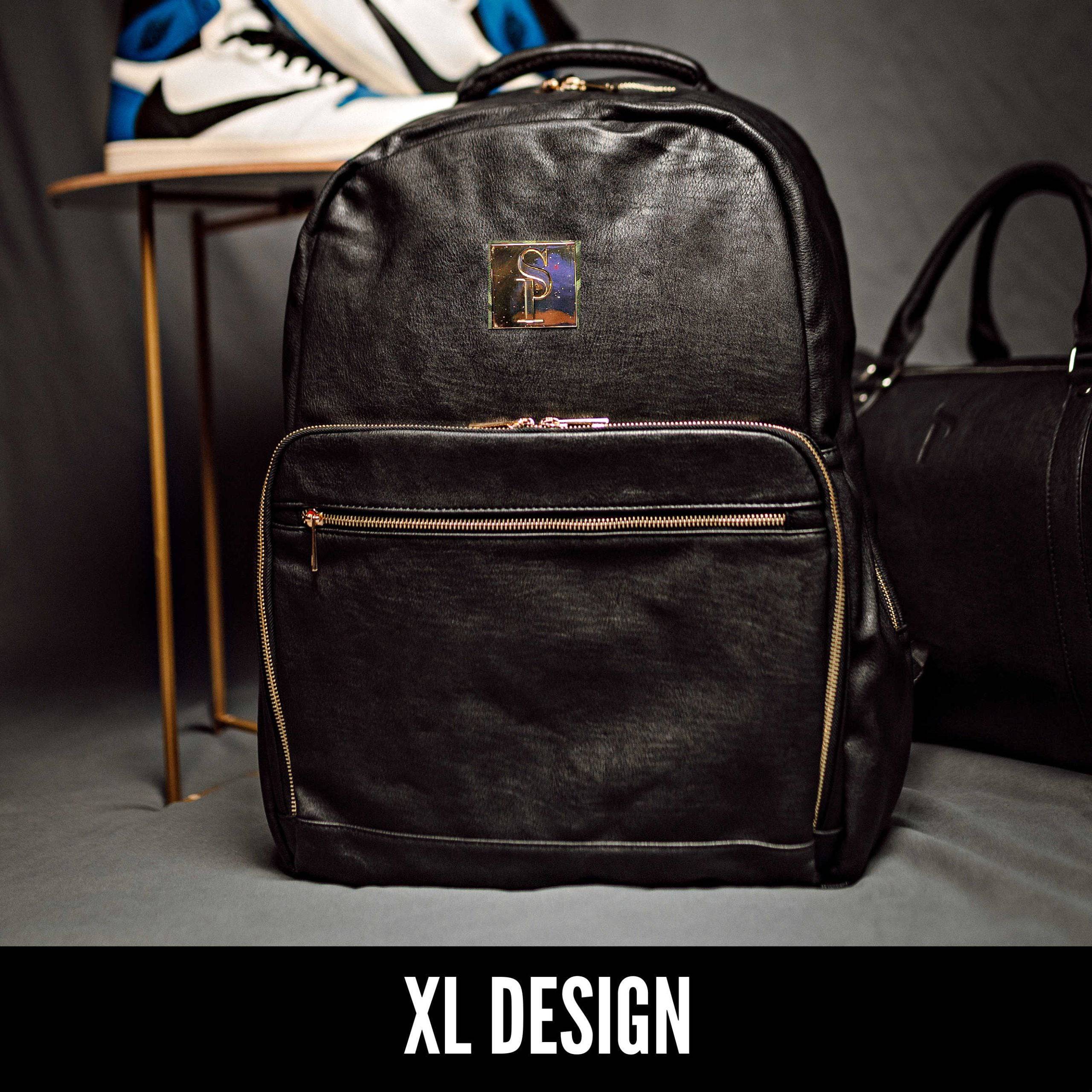 Black backpack with gold zippers on a gray surface, with 'XL Design' branding.