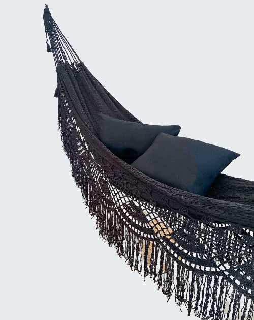 Black hammock with pillows in a room with decorative elements
