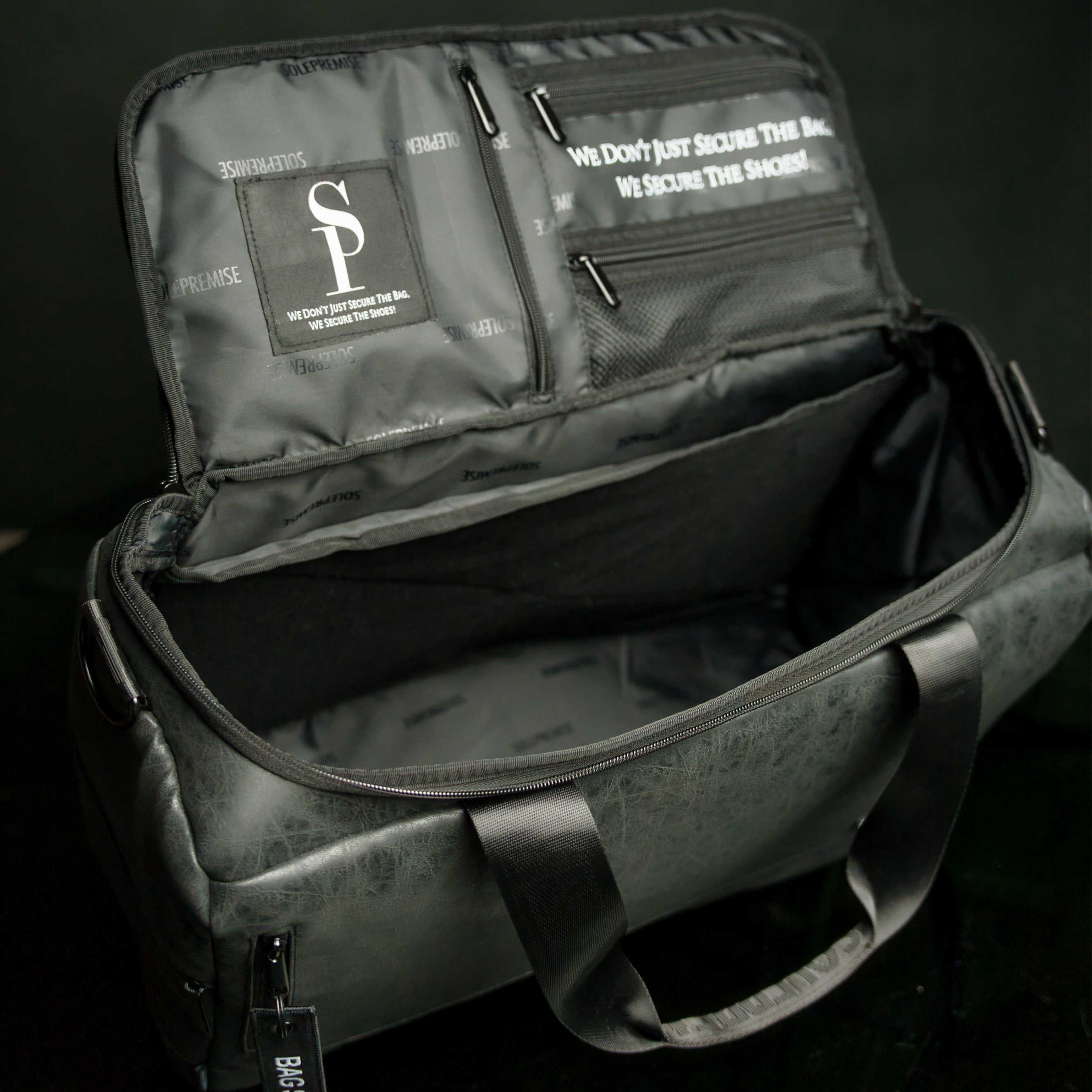 Open black bag with interior details and a visible brand logo on a dark background