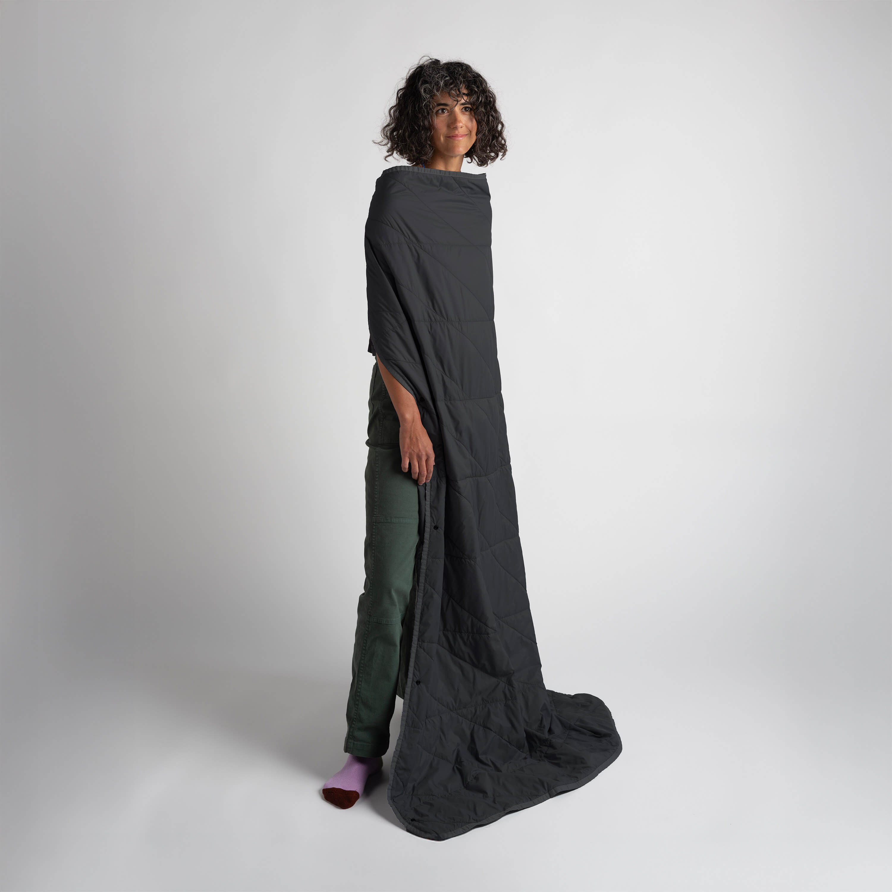 Person wearing a long dark gray garment on a white background