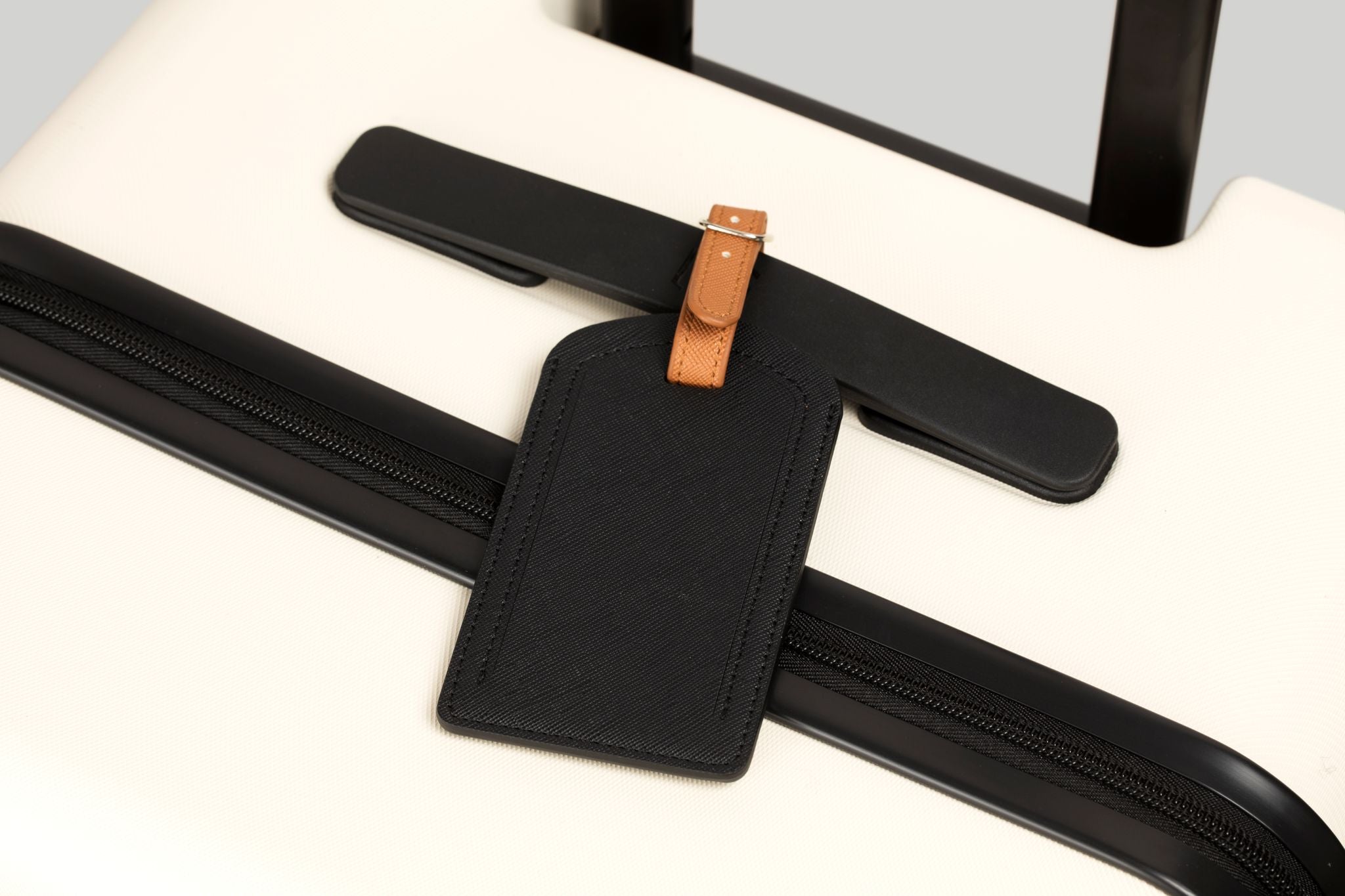 Black strap with a brown buckle on a white surface