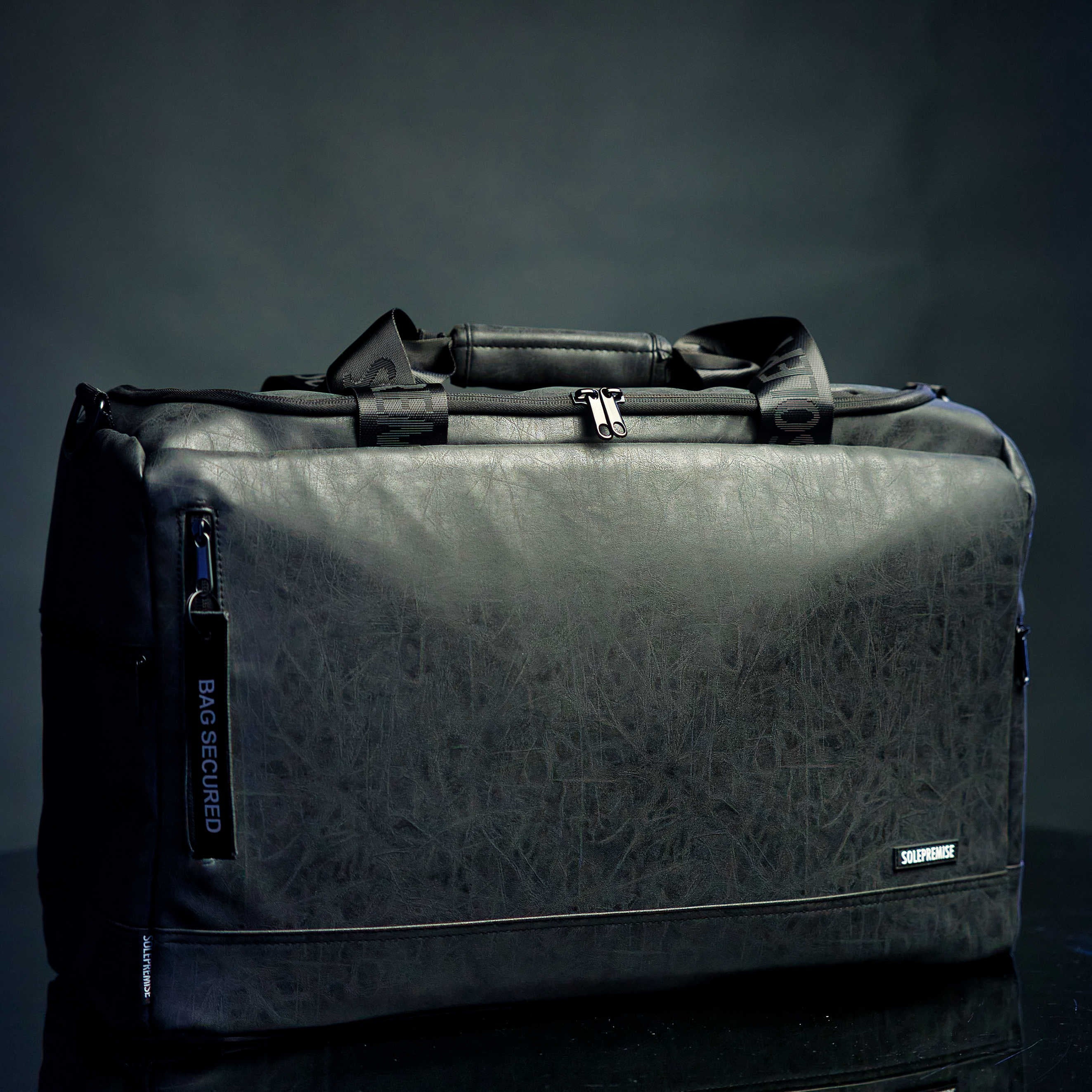 Black duffel bag with geometric pattern on a dark background