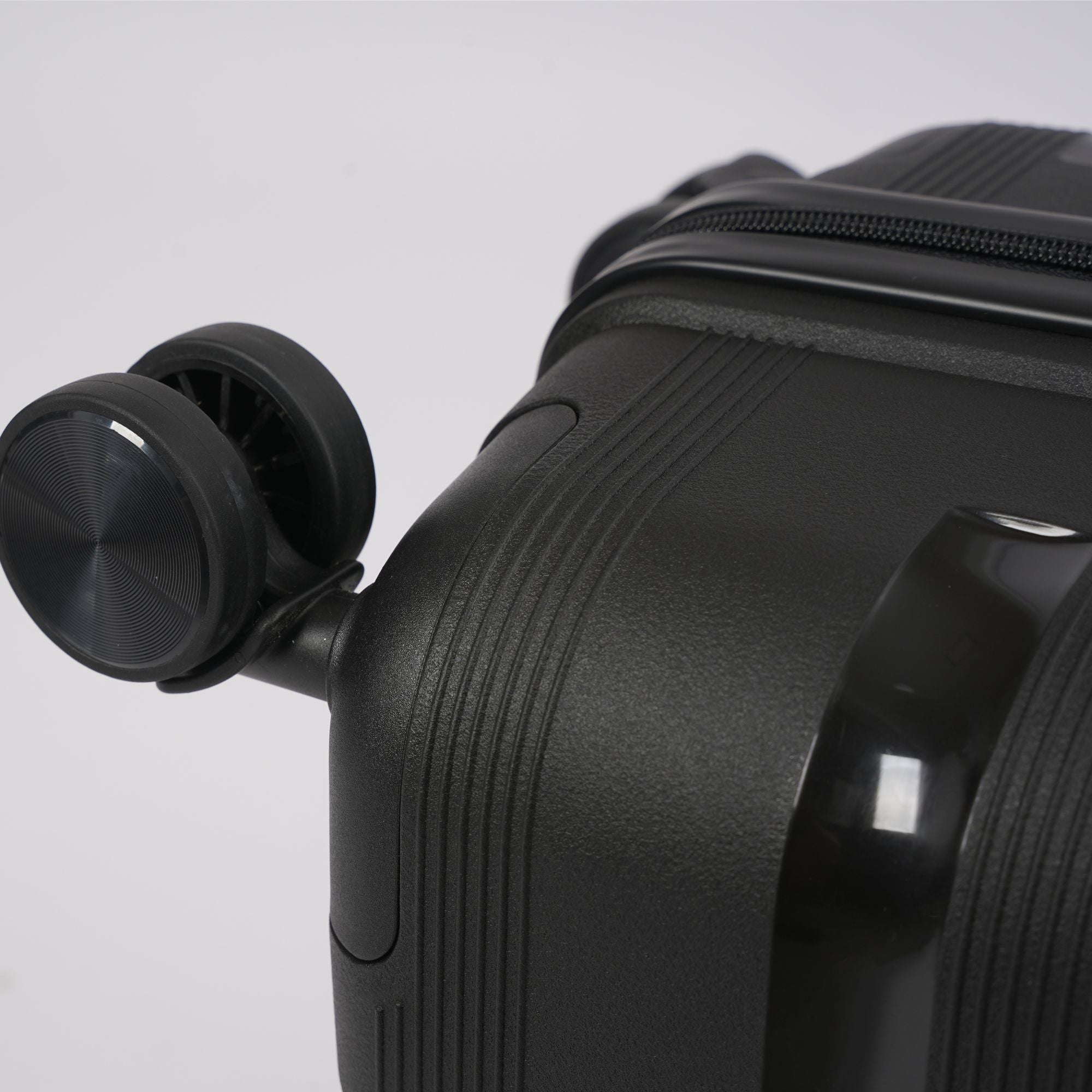 Black suitcase with wheels on a light gray background