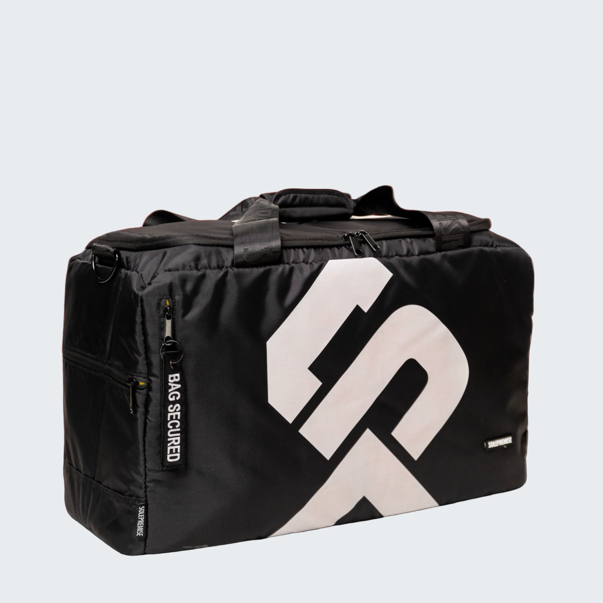 Black duffel bag with a prominent logo on a red background