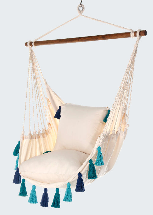 Beige hammock chair with blue and green tassels on a white background