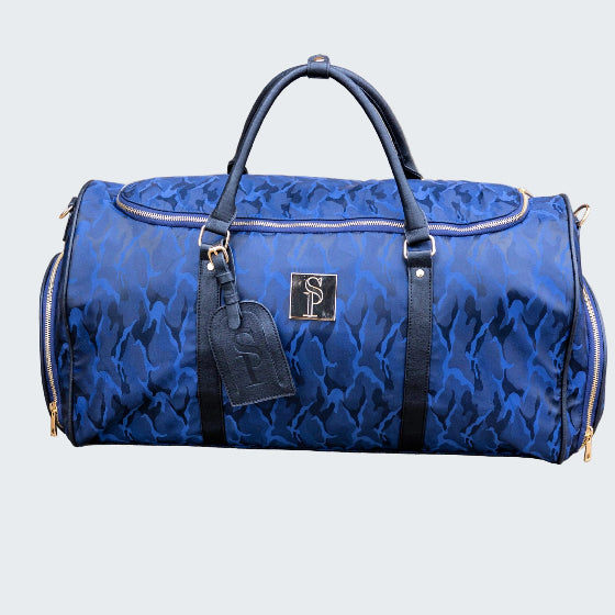 Blue duffel bag with a brand logo on a beige surface