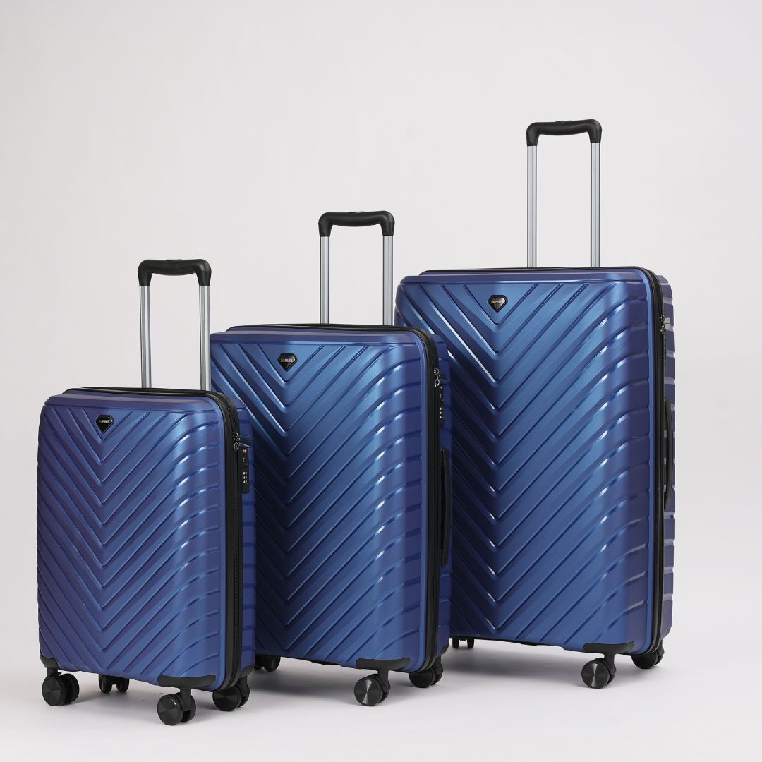 Set of three blue suitcases with chevron pattern on a light gray background