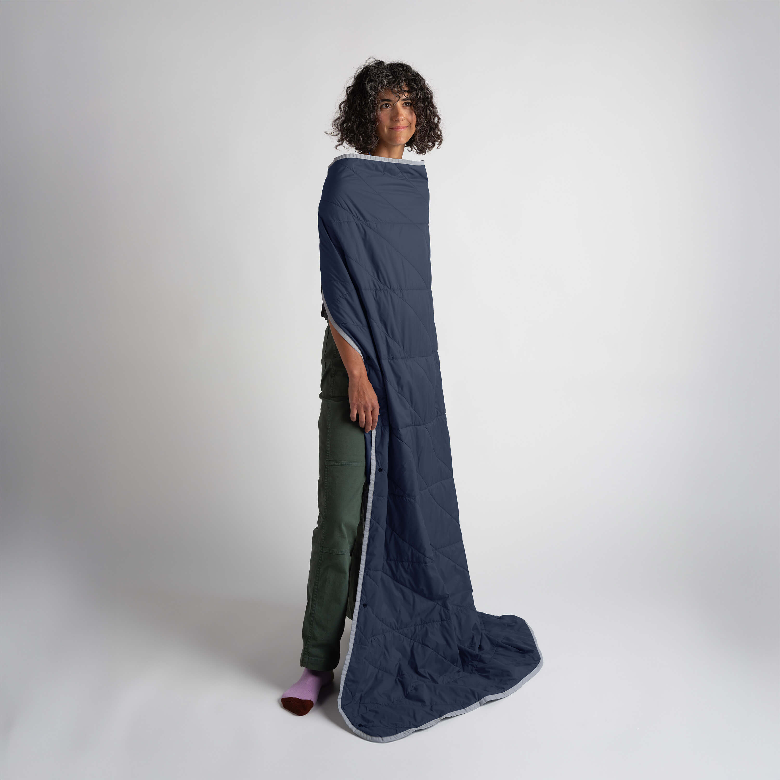 Person wearing a long navy blue garment on a white background