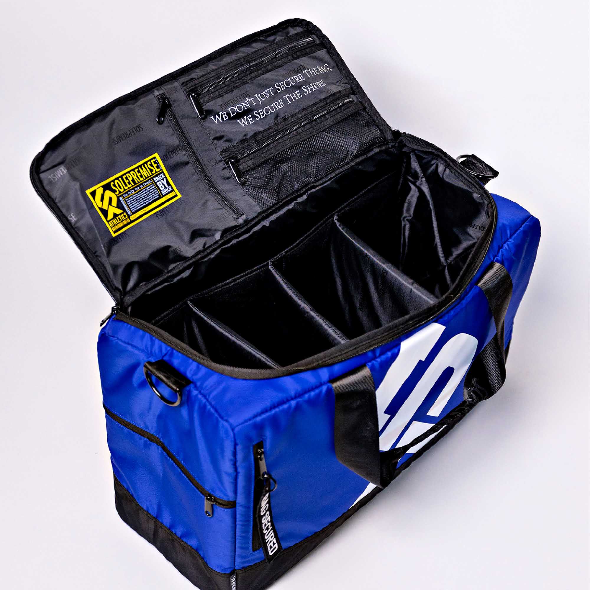 Blue duffel bag with black interior compartments on a white background