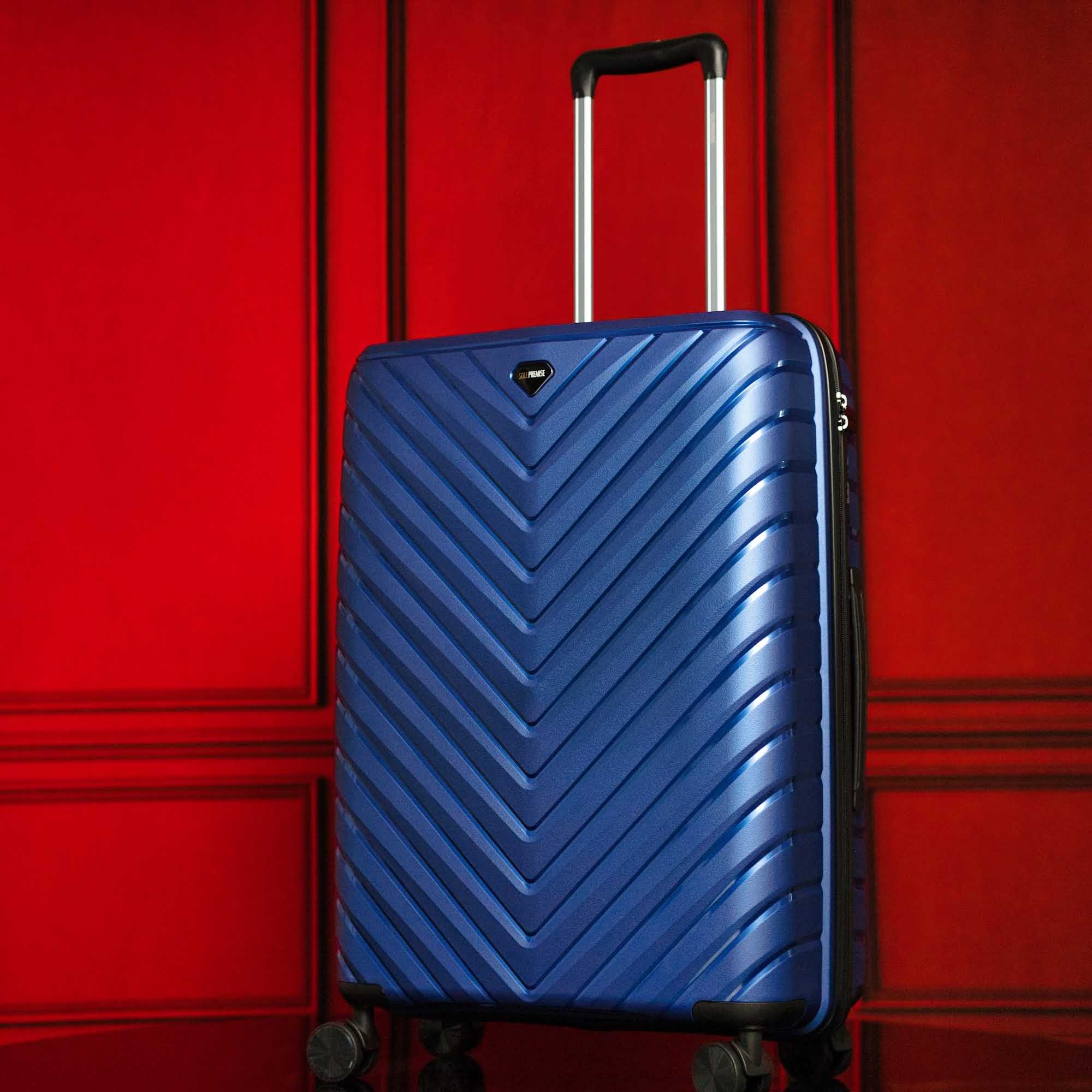 Blue suitcase with a chevron pattern on a red background