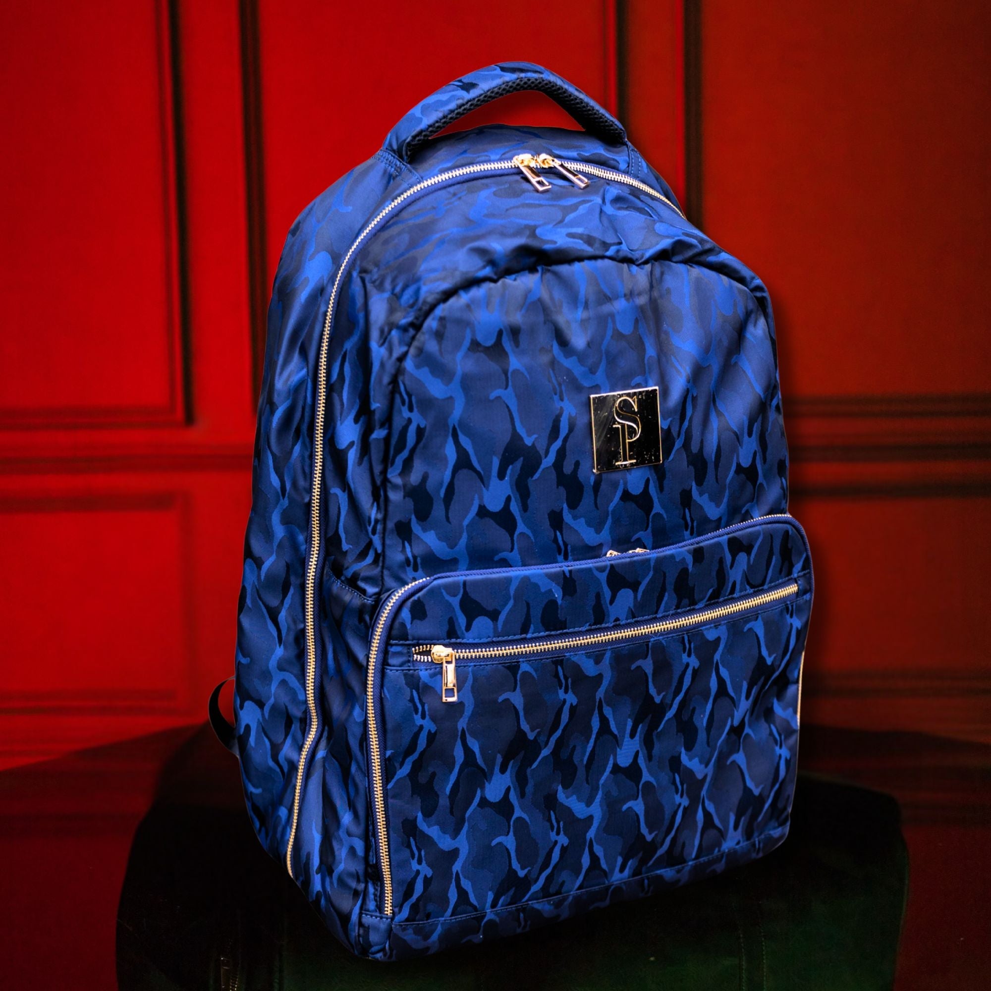 Blue patterned backpack with a brand logo on a red background