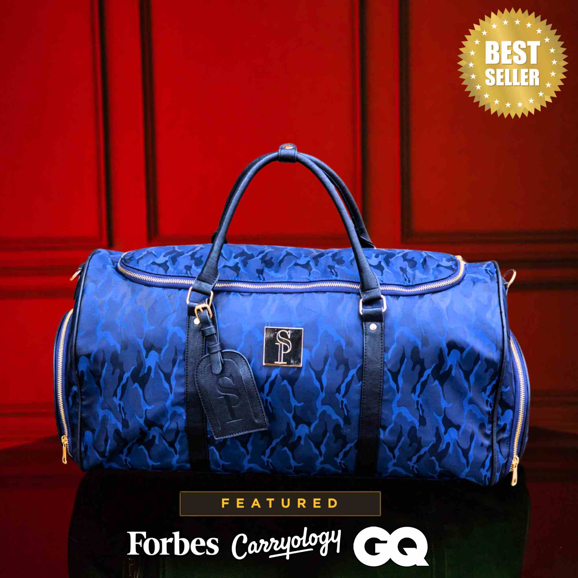 Blue duffel bag with quilted pattern on a red background, featuring 'Forbes Carryology' and 'GQ' logos.