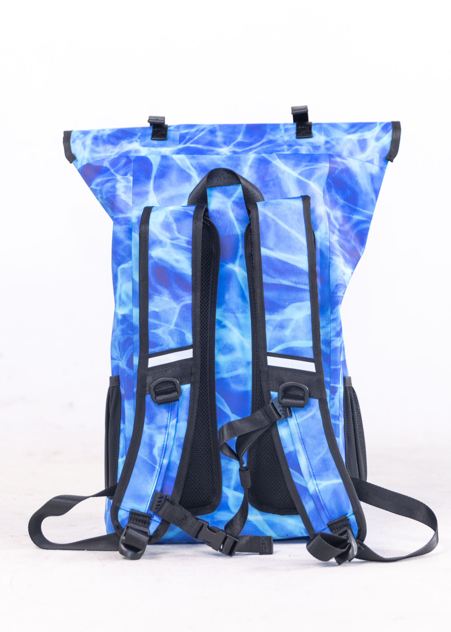 Blue water-patterned backpack with black straps on a white background