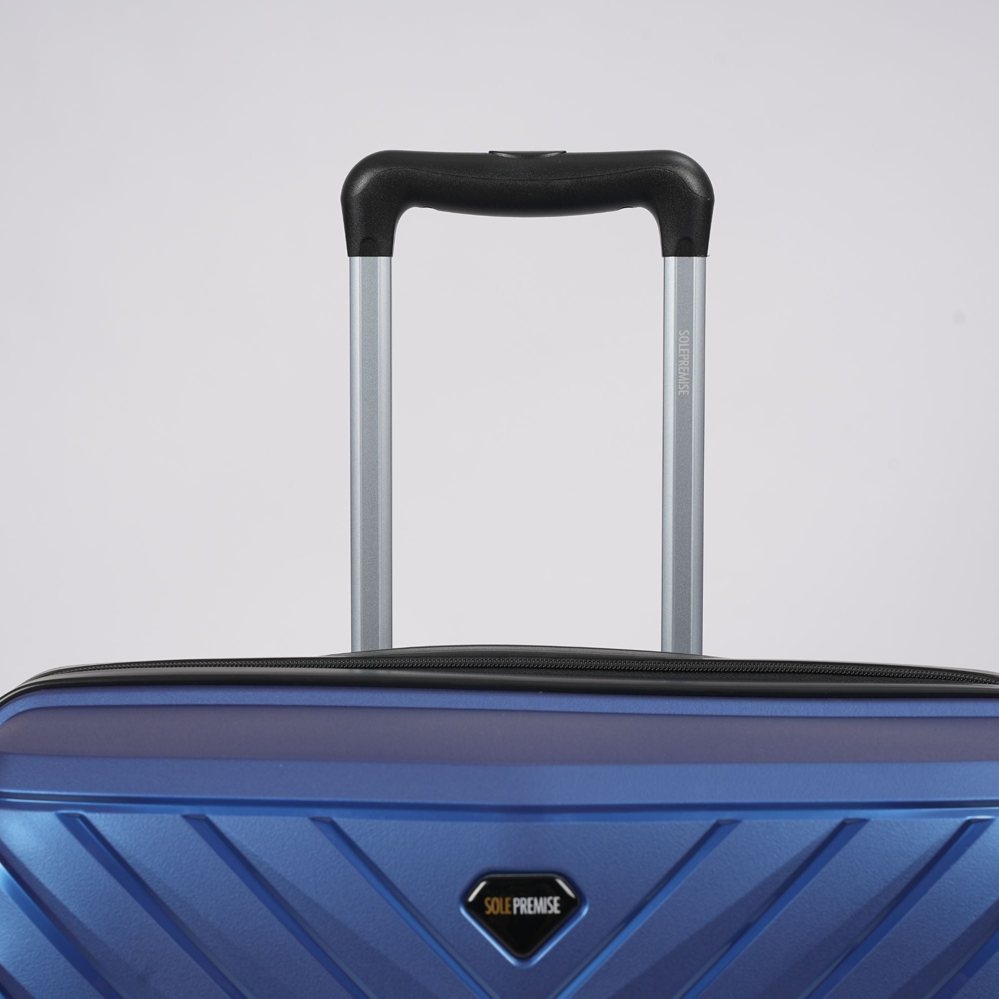 Blue suitcase with a black handle on a light gray background