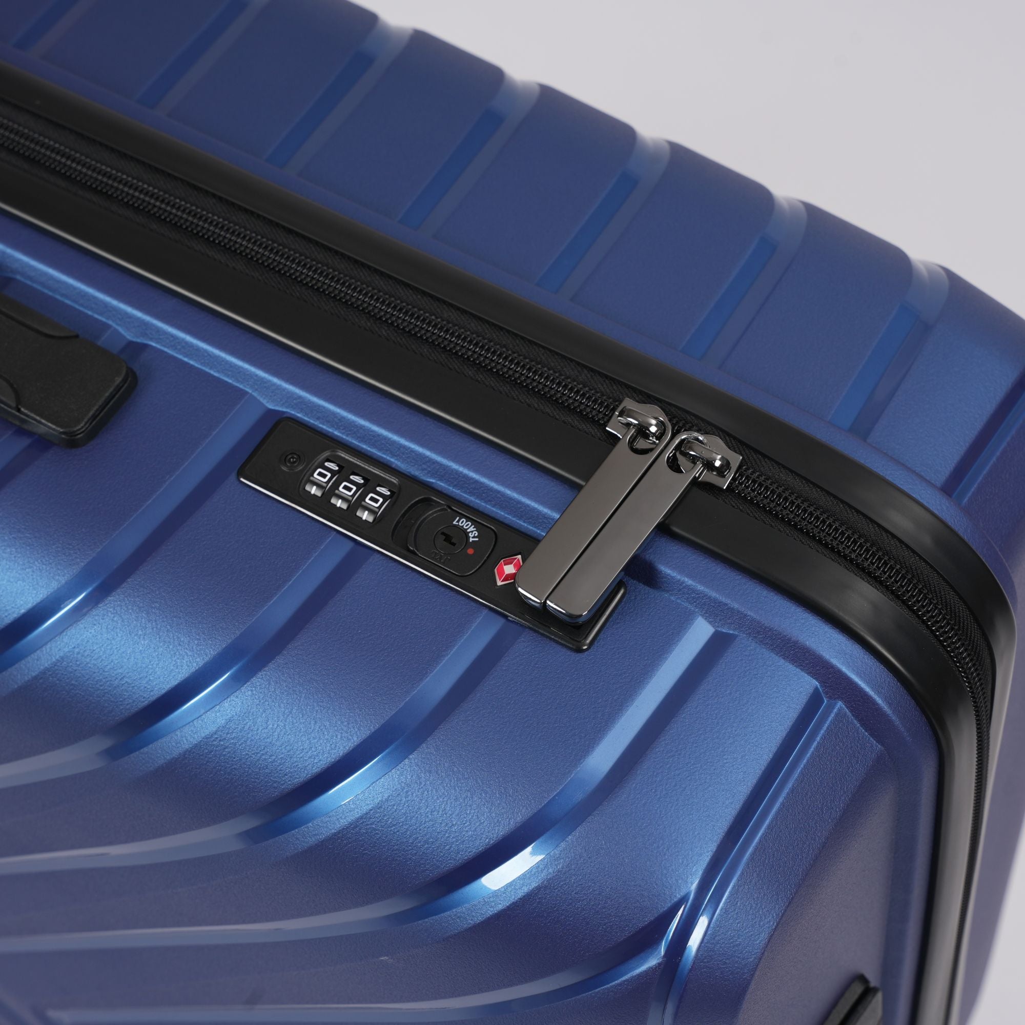 Close-up of a blue suitcase with a zipper and lock mechanism on a light gray background