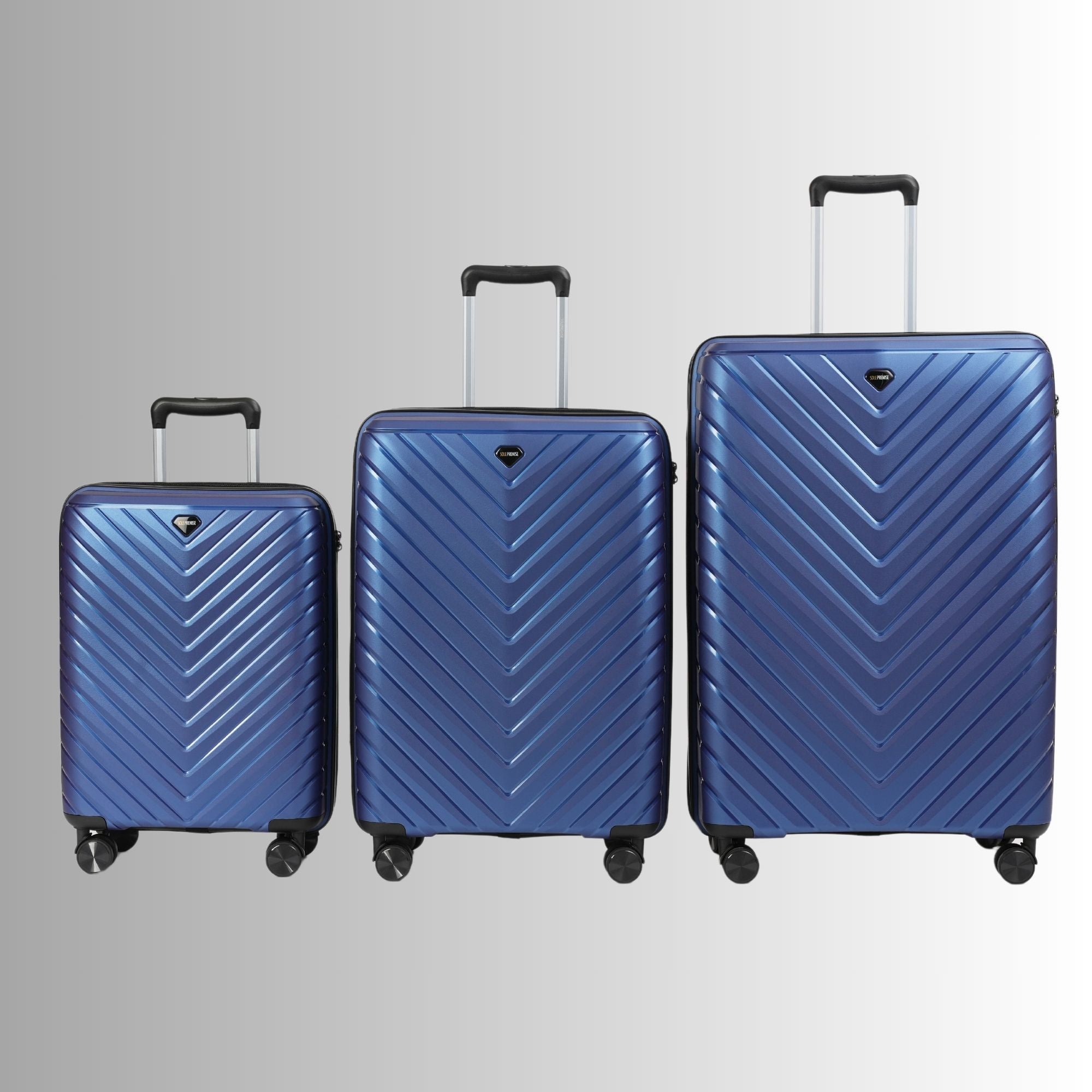 Three blue suitcases of different sizes on a gray background