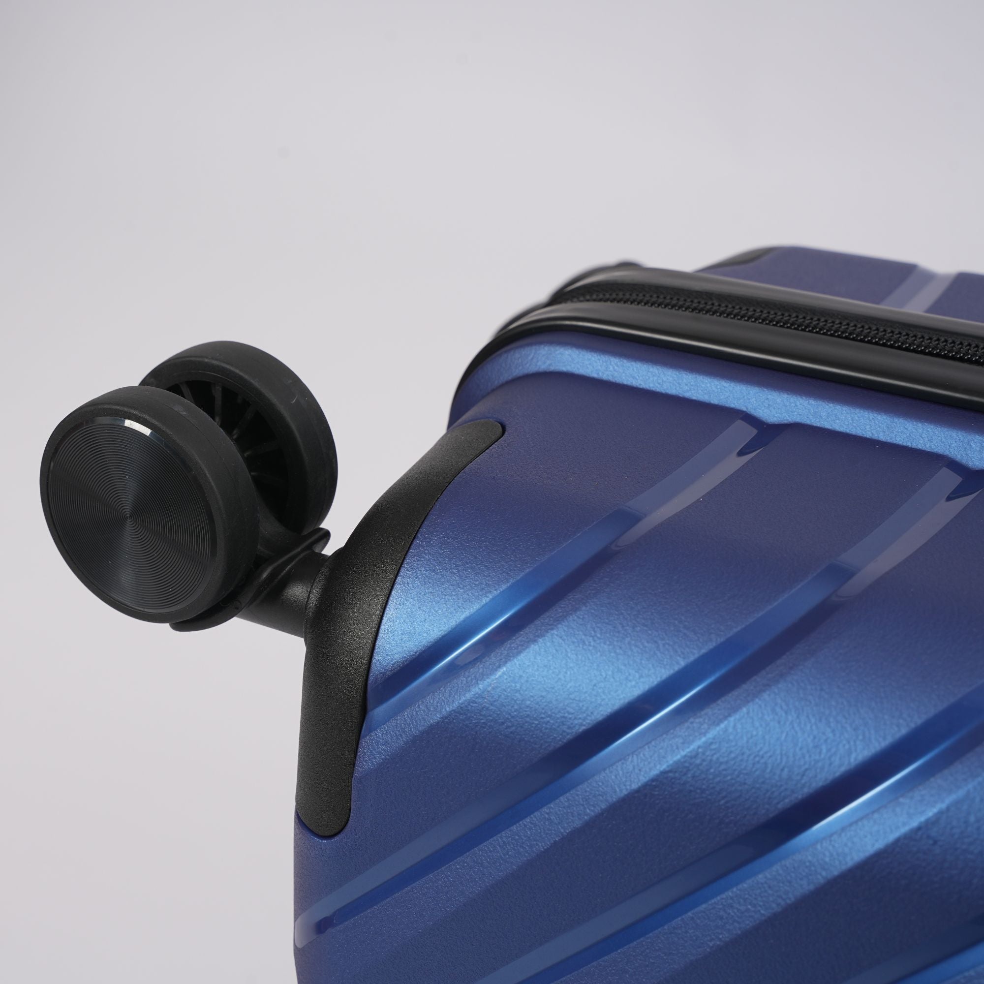 Blue suitcase with a black wheel on a light gray background