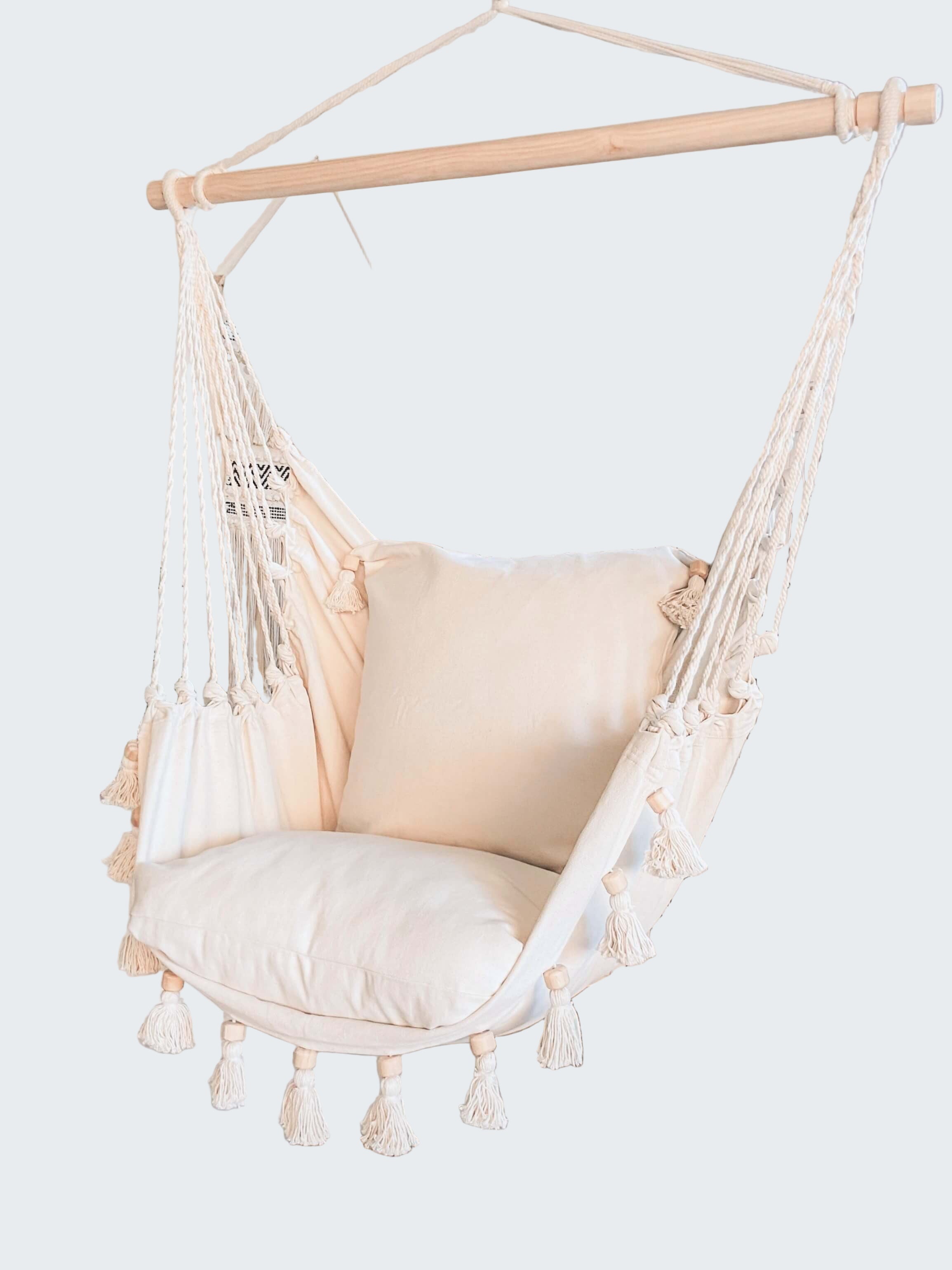 White hammock chair with tassels in a room with decorative elements