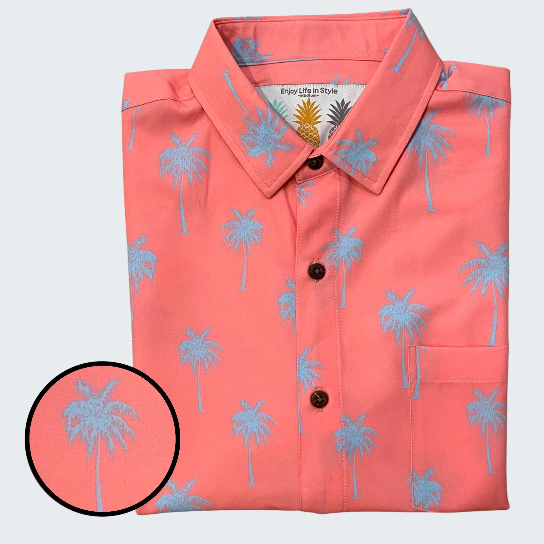 Folded coral shirt with blue palm tree pattern on a white background