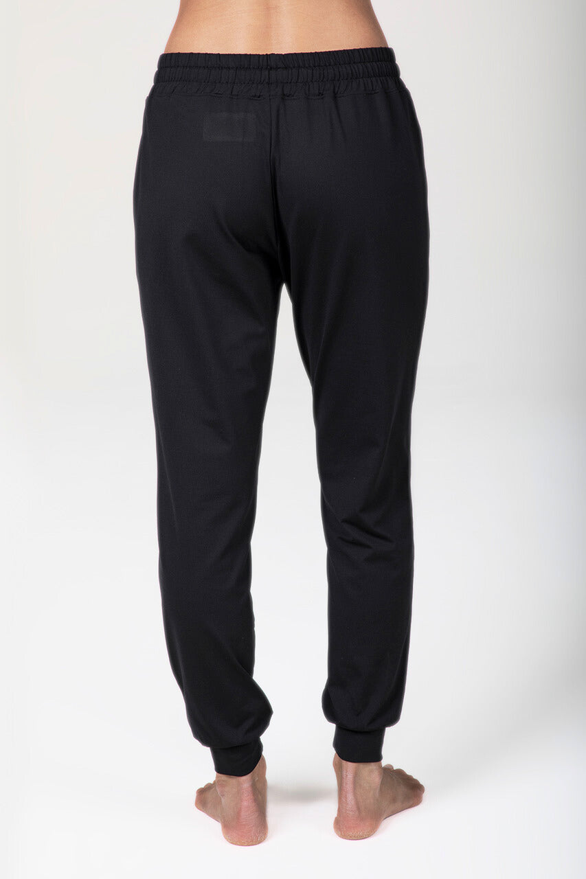 Black sweatpants worn by a person on a white background