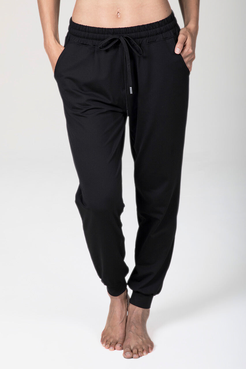 Black jogger pants worn by a person on a white background