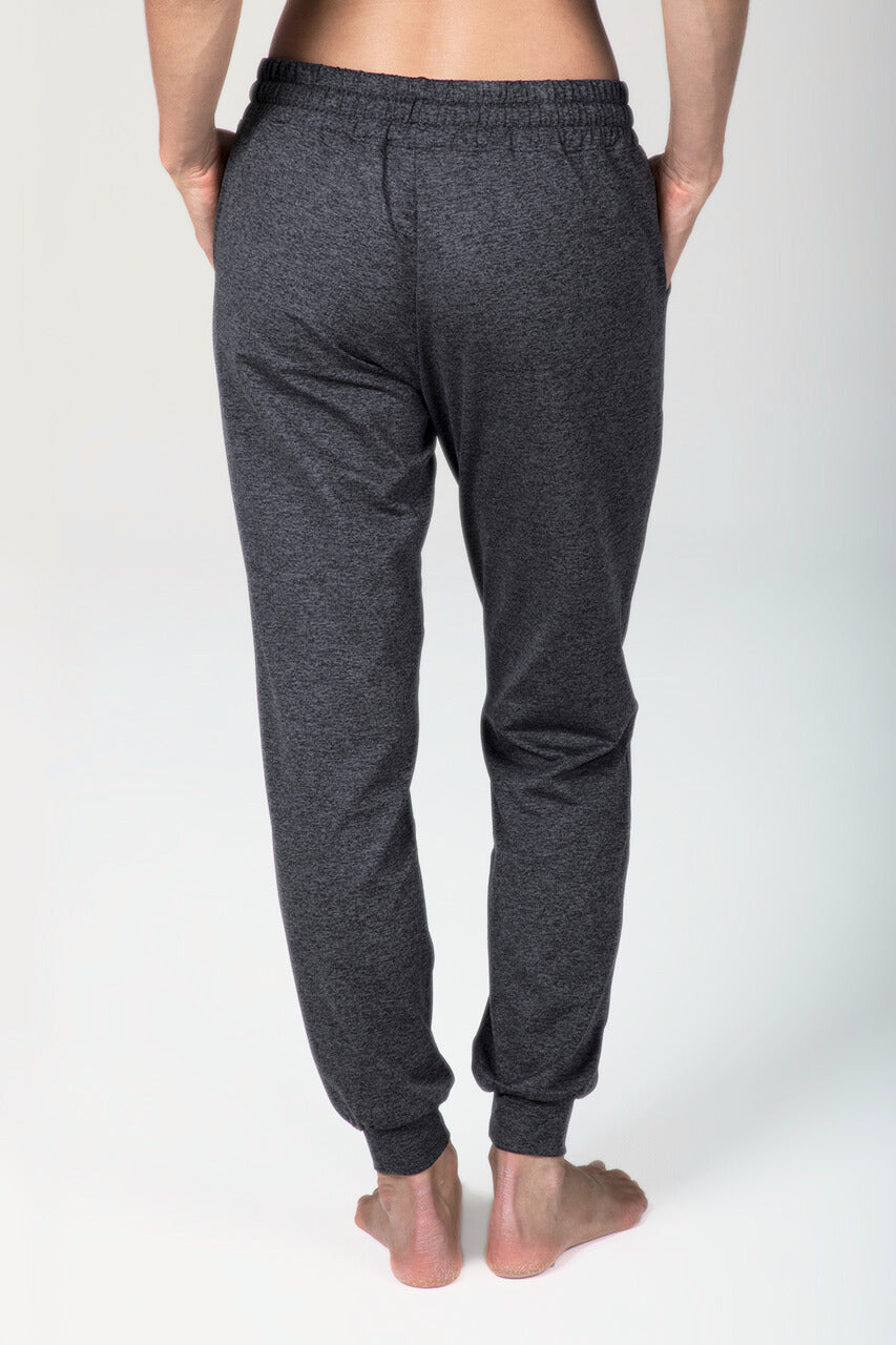 Person wearing dark gray sweatpants on a white background