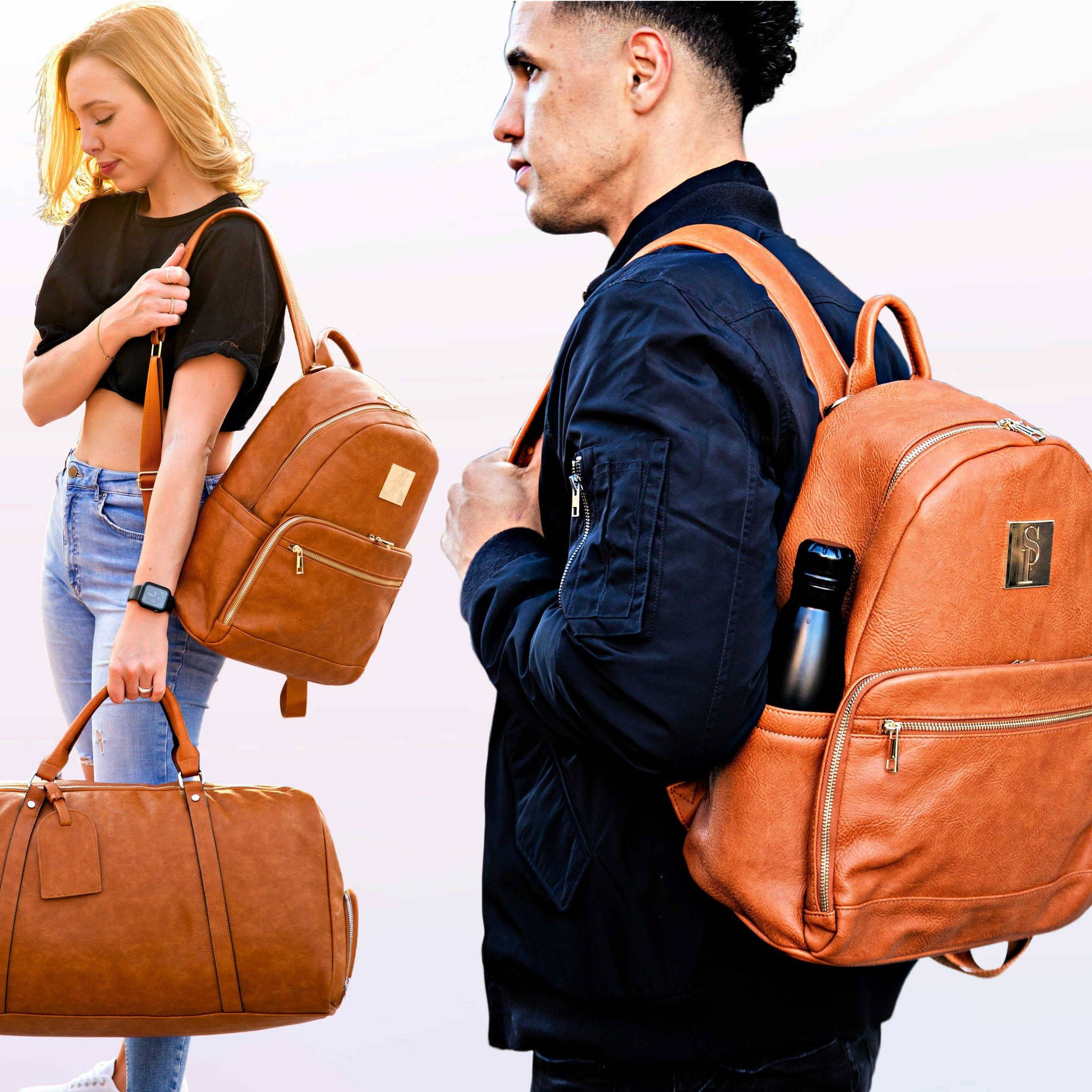 Two people wearing brown leather backpacks and a duffel bag on a plain background