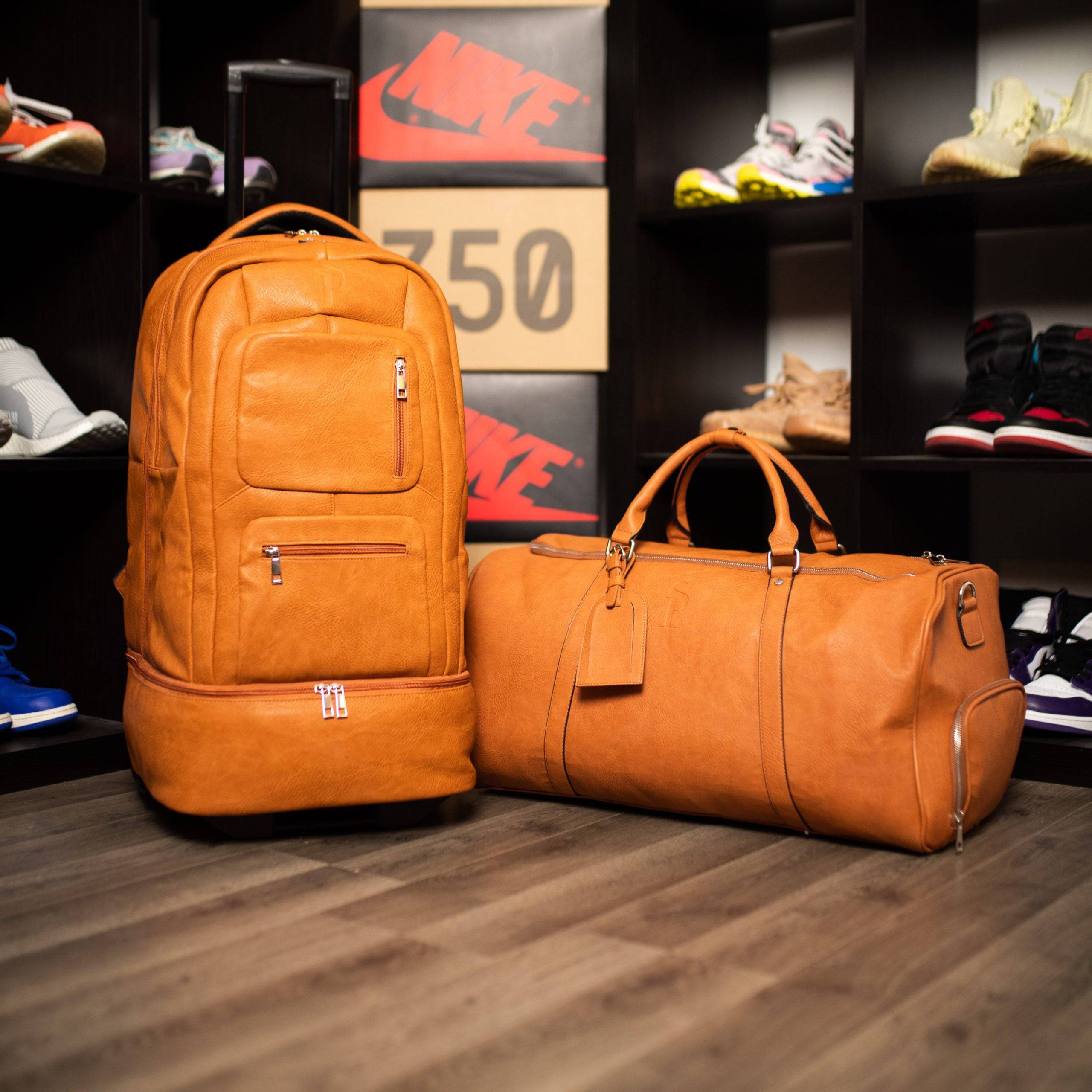 Two orange leather bags on a wooden floor with shelves displaying shoes in the background.