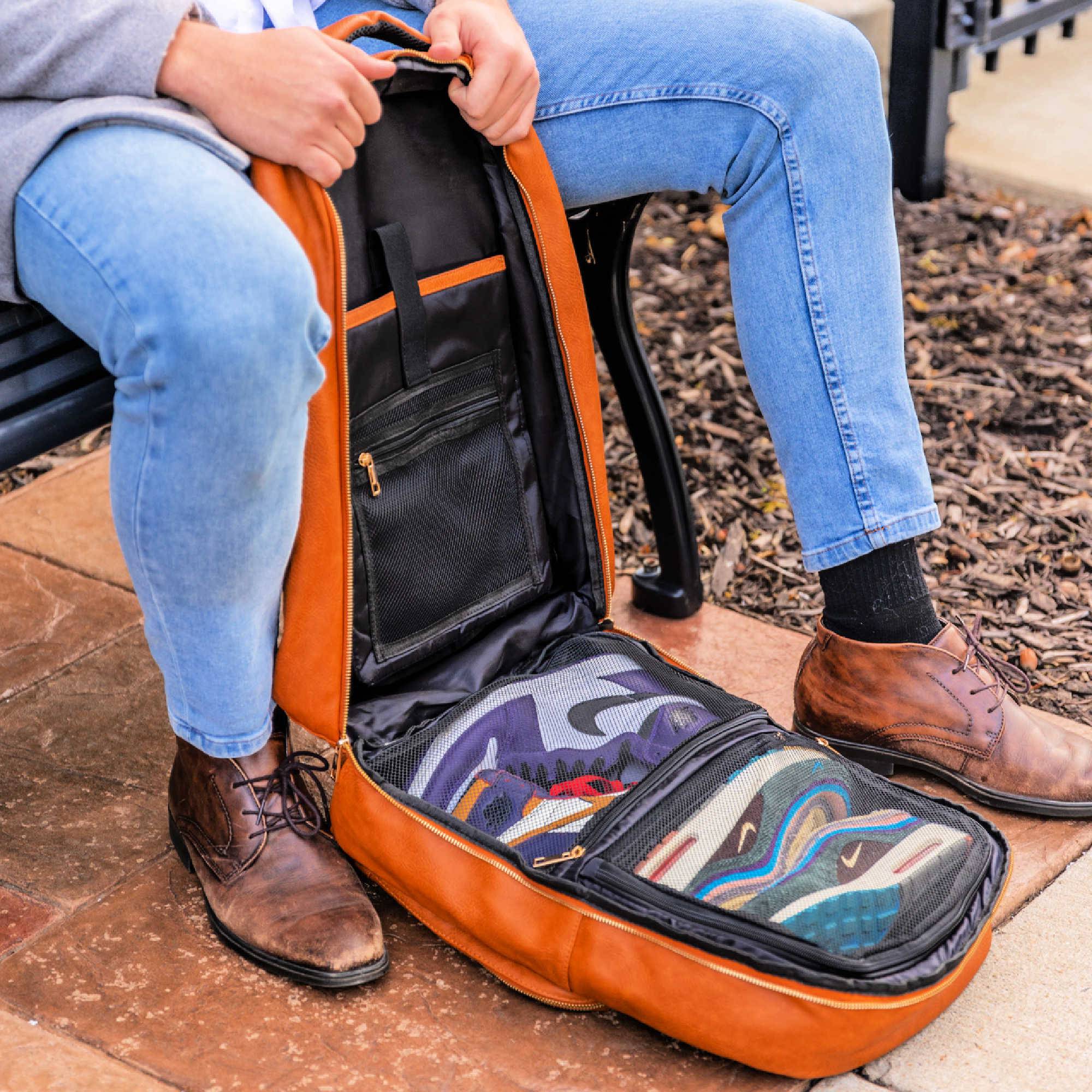 Person sitting on a bench with an open orange guitar case containing a guitar