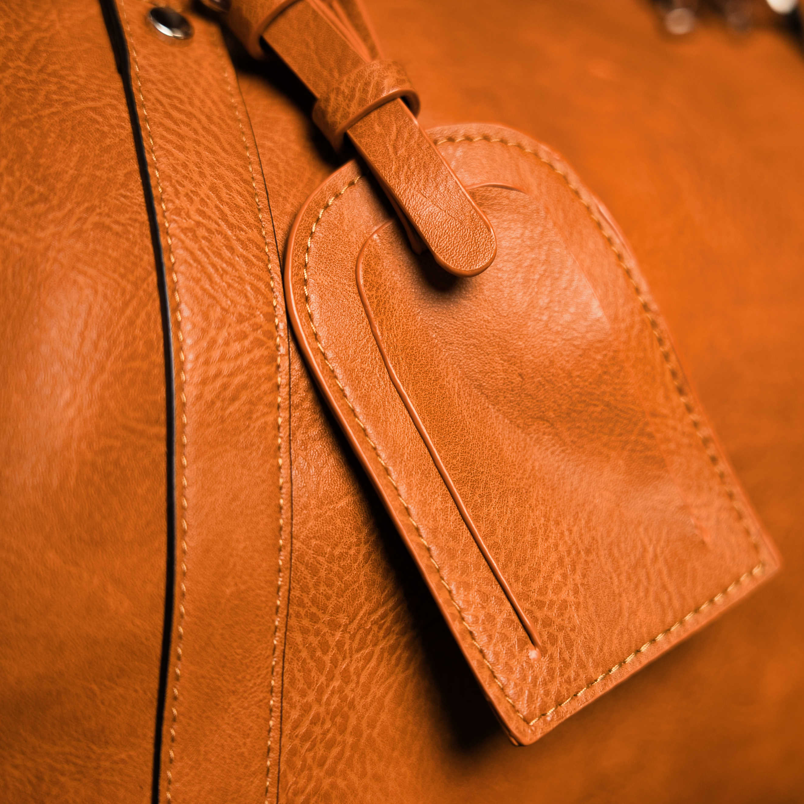 Close-up of a brown leather bag with a matching tag