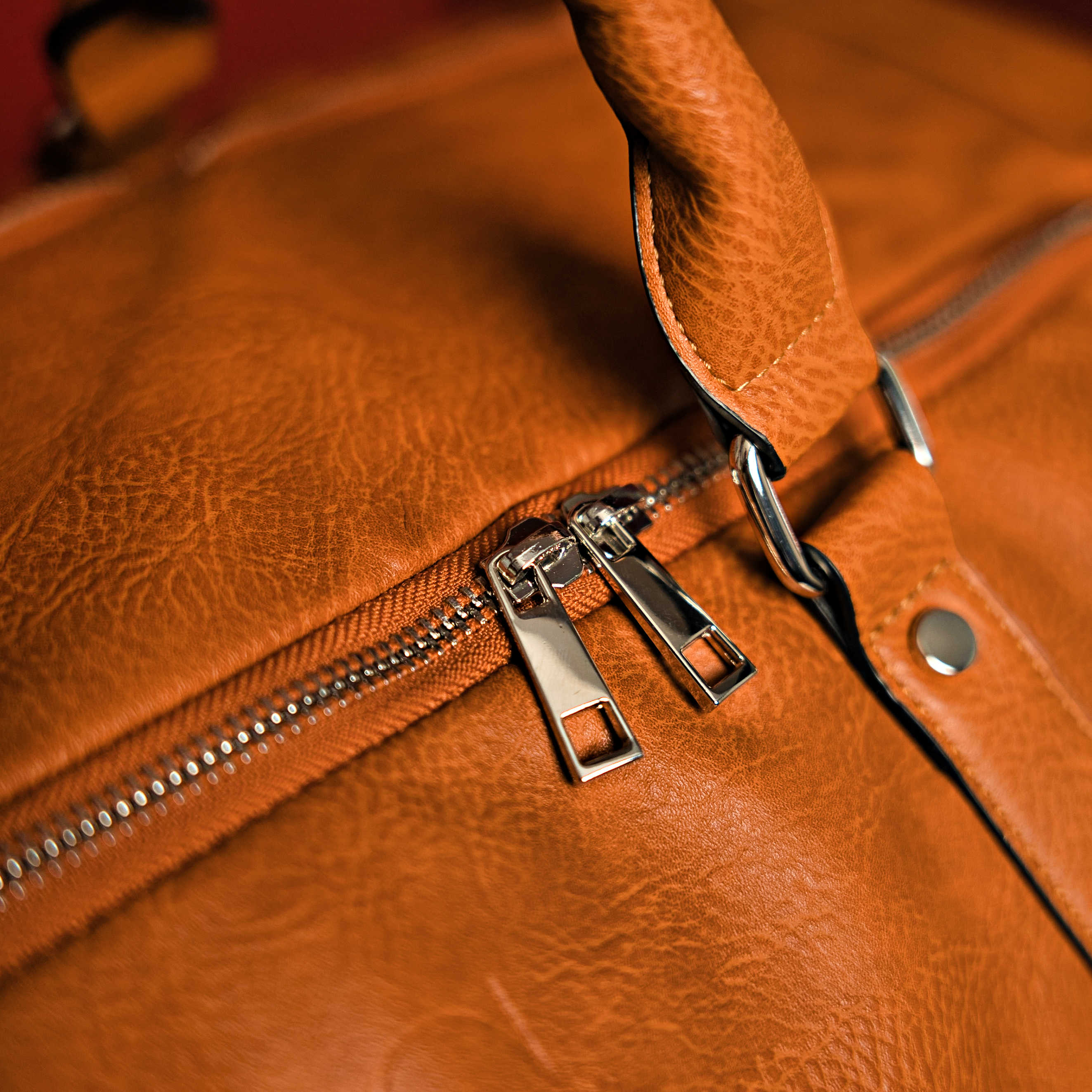 Close-up of a brown leather bag with a zipper
