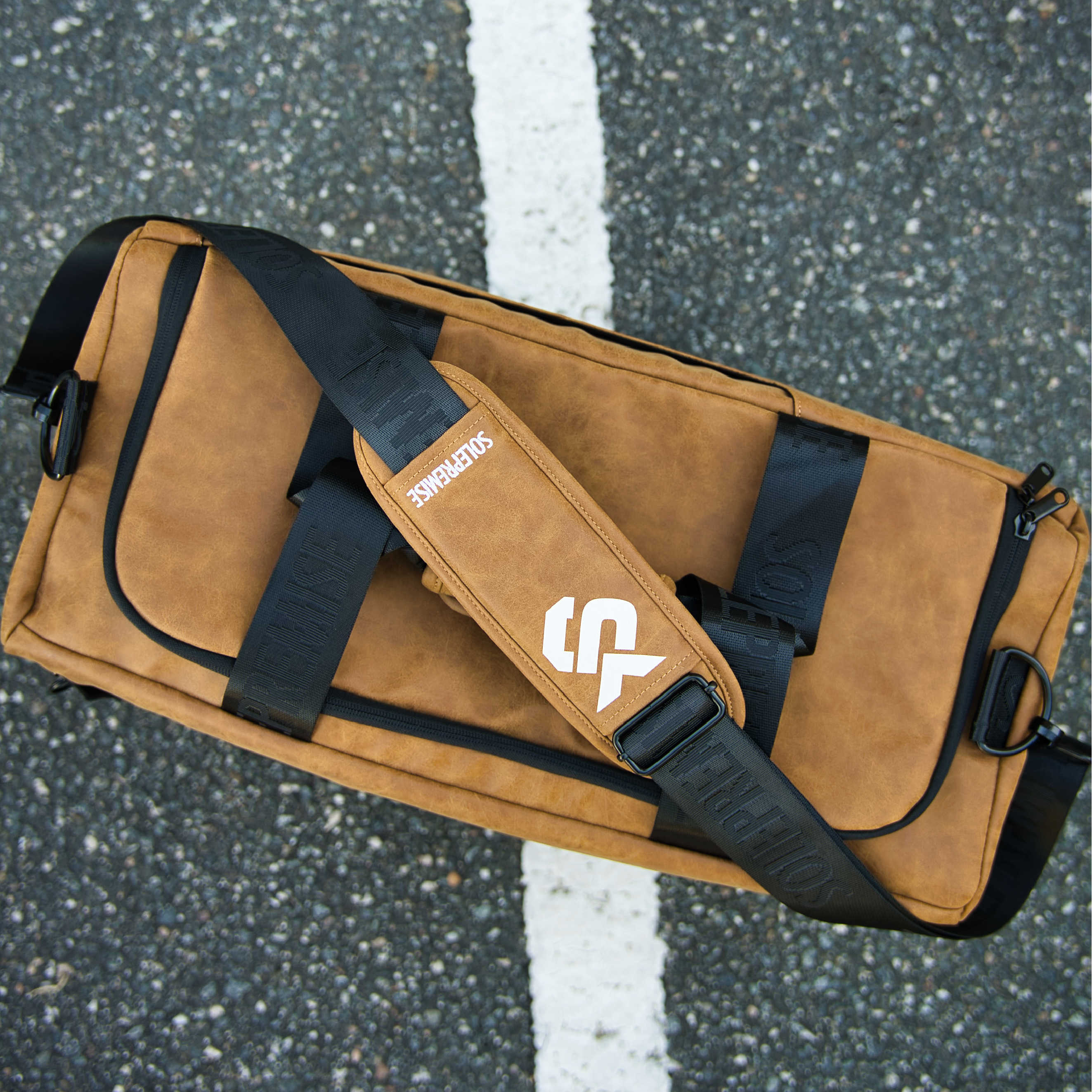 Brown bag with black straps on a textured surface