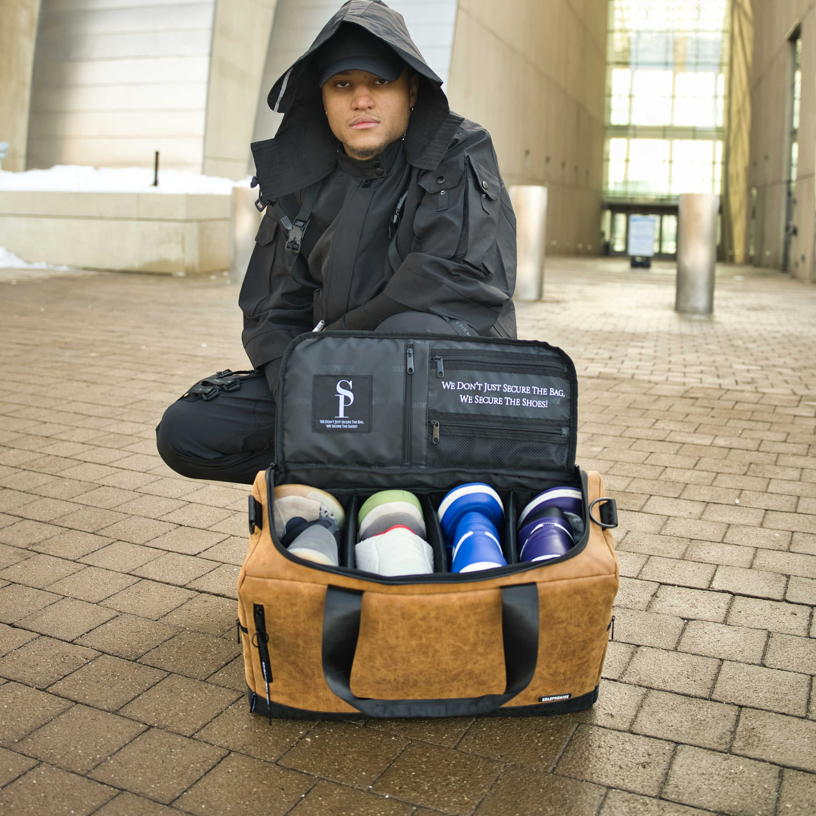 Person sitting on a bench with a tan duffel bag containing shoes, outdoors.
