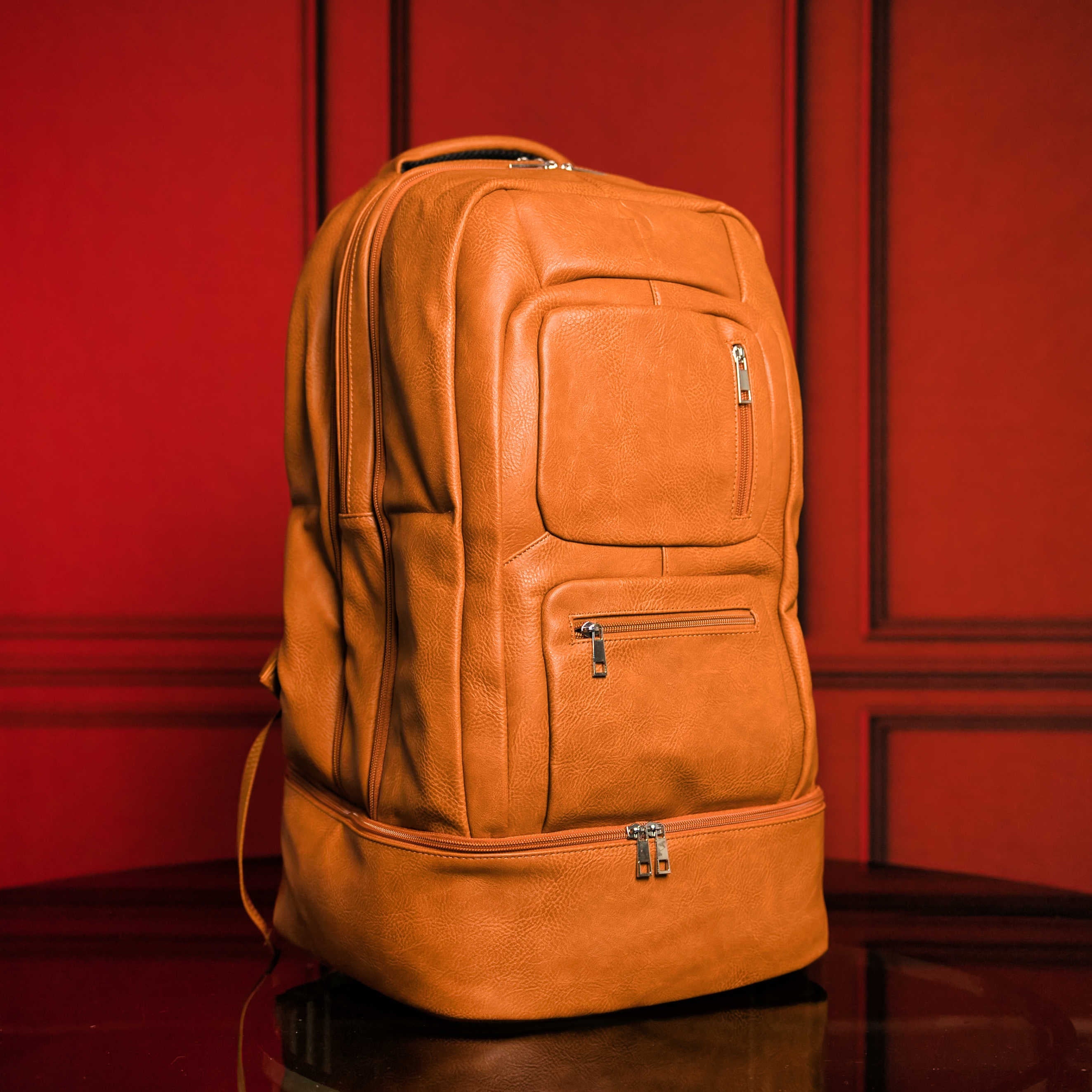 Orange leather backpack on a red background
