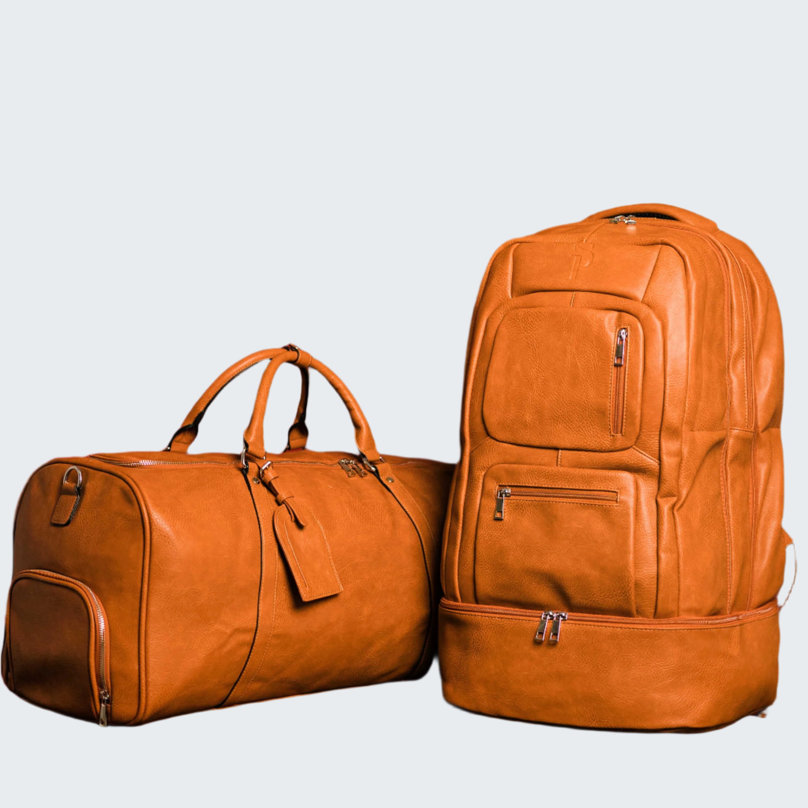 Two brown leather bags, a duffel bag and a backpack, against a red background.