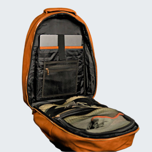 Open brown backpack with compartments against a red paneled wall