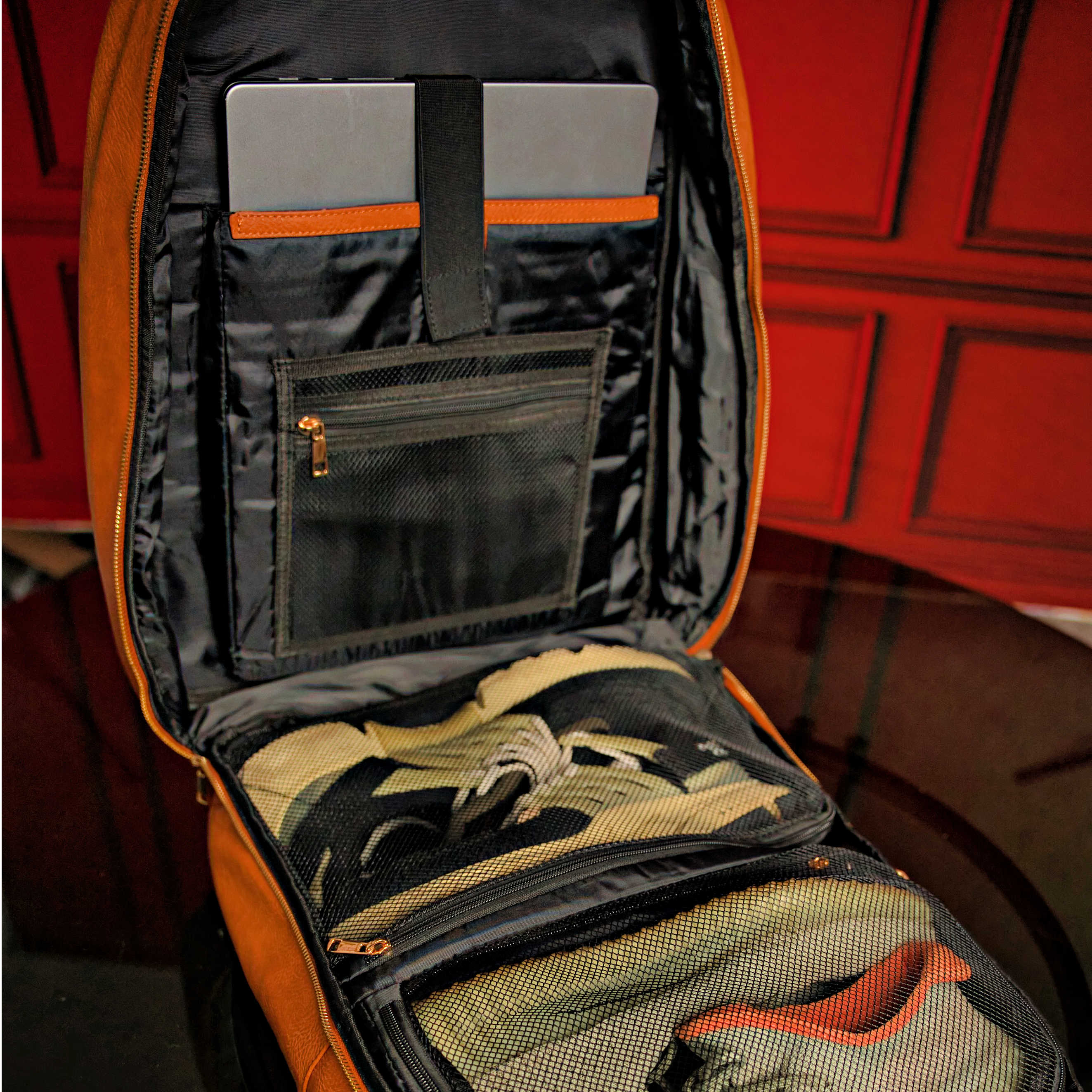 Open backpack with compartments and a red background