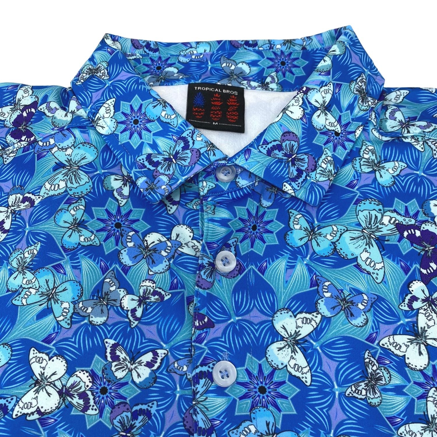 Blue floral and butterfly patterned shirt with a brand label on a white background