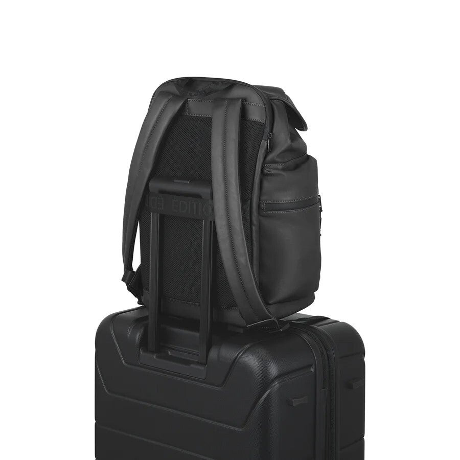Black backpack on top of a black suitcase on a white background