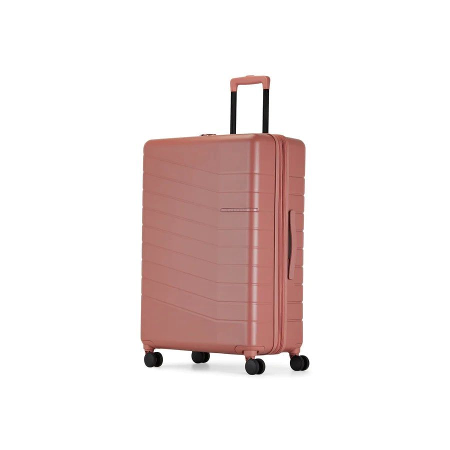Pink suitcase with a textured surface on a white background