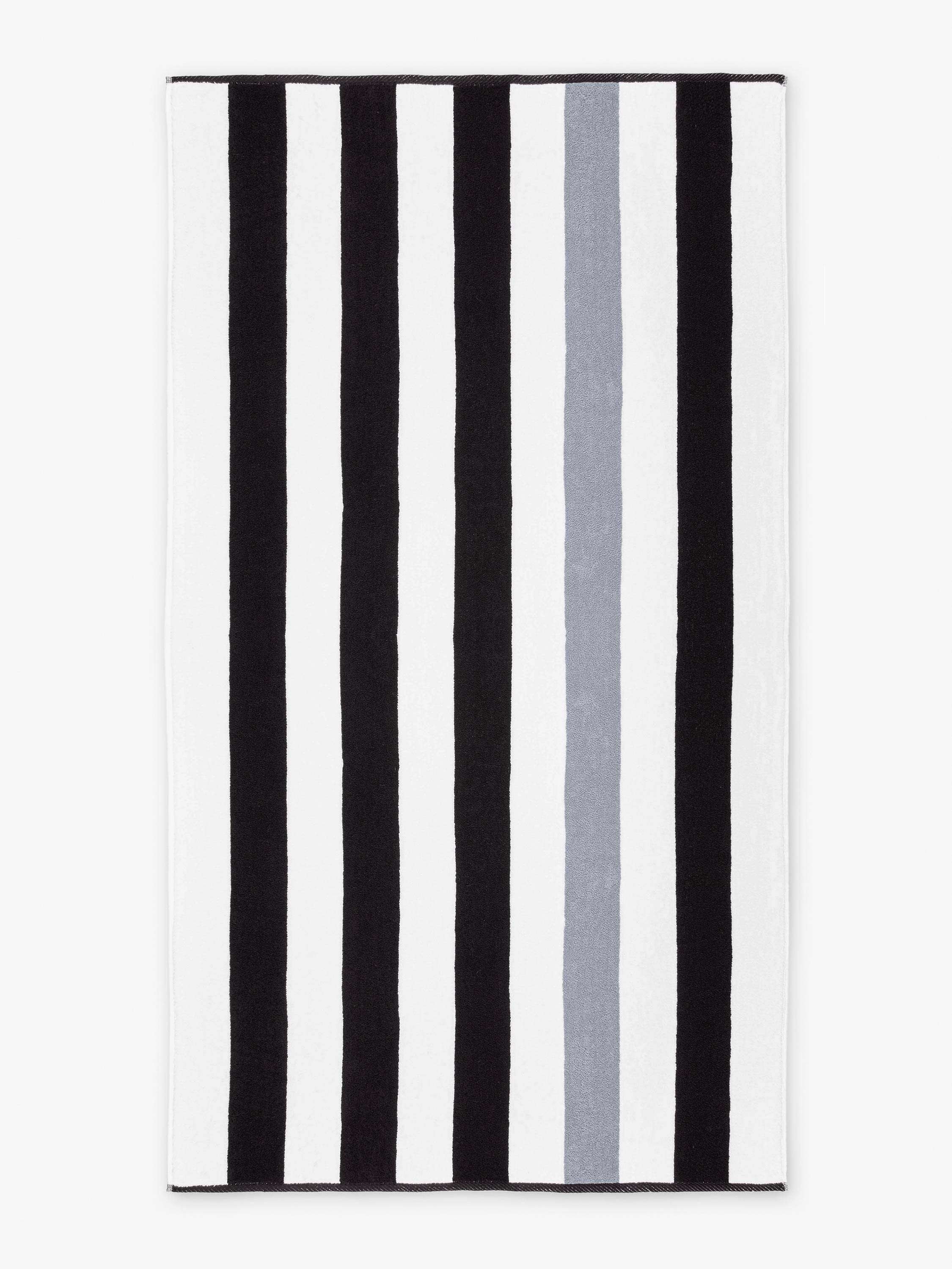 Striped rug with black, white, and gray vertical stripes on a white background