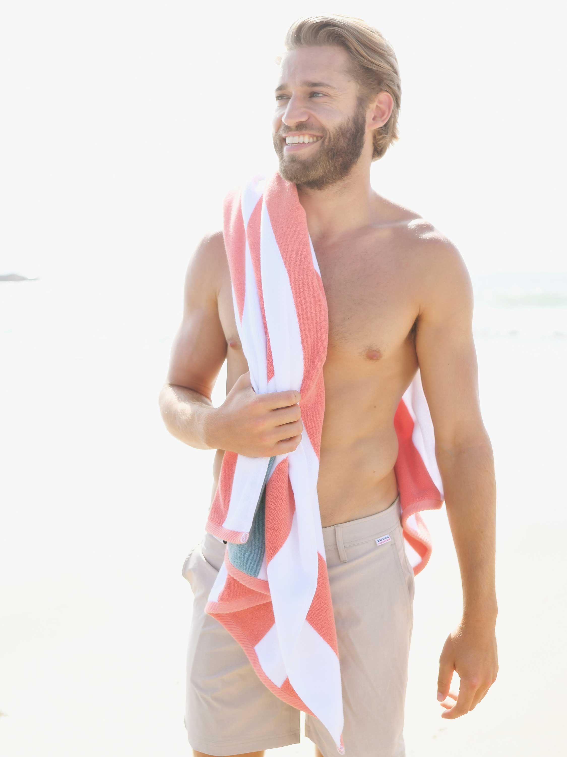 Man holding a red and white striped towel on a white background
