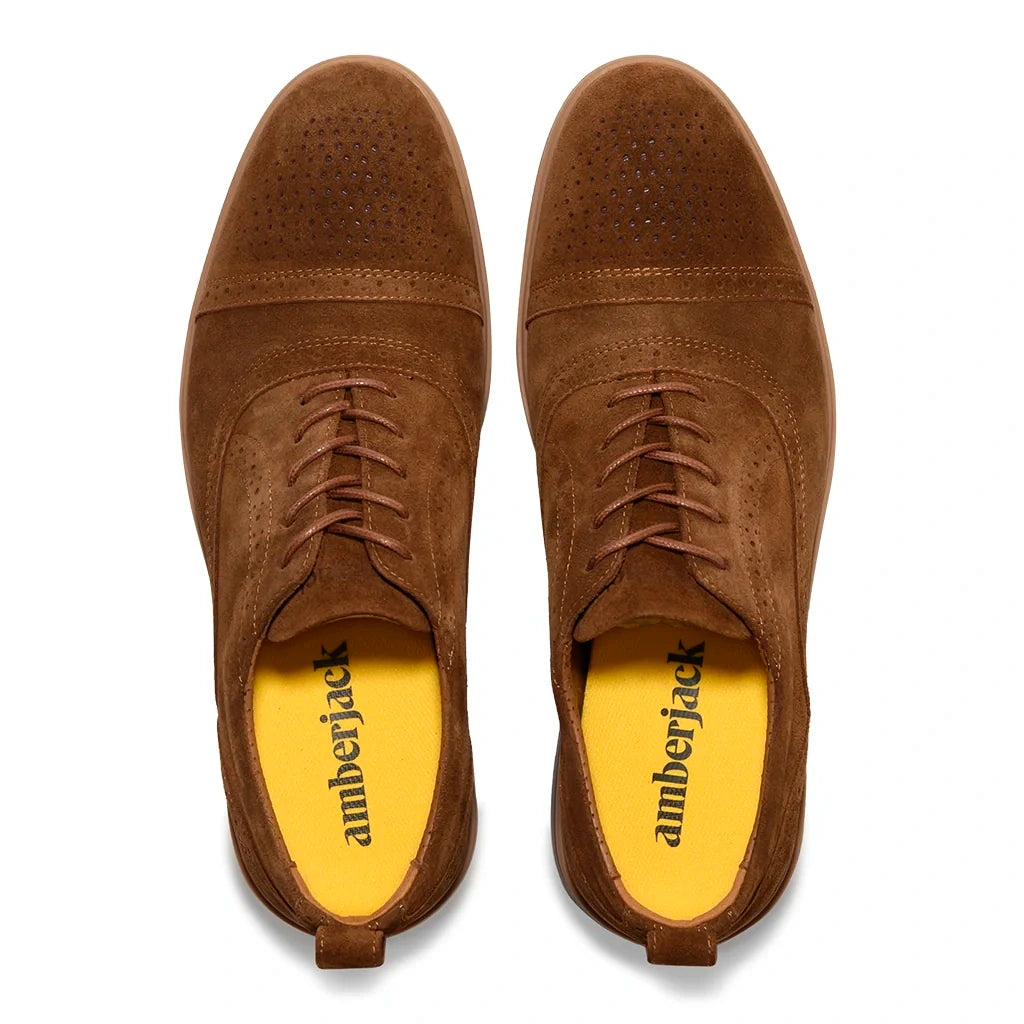 Brown suede shoes with yellow soles on a white background