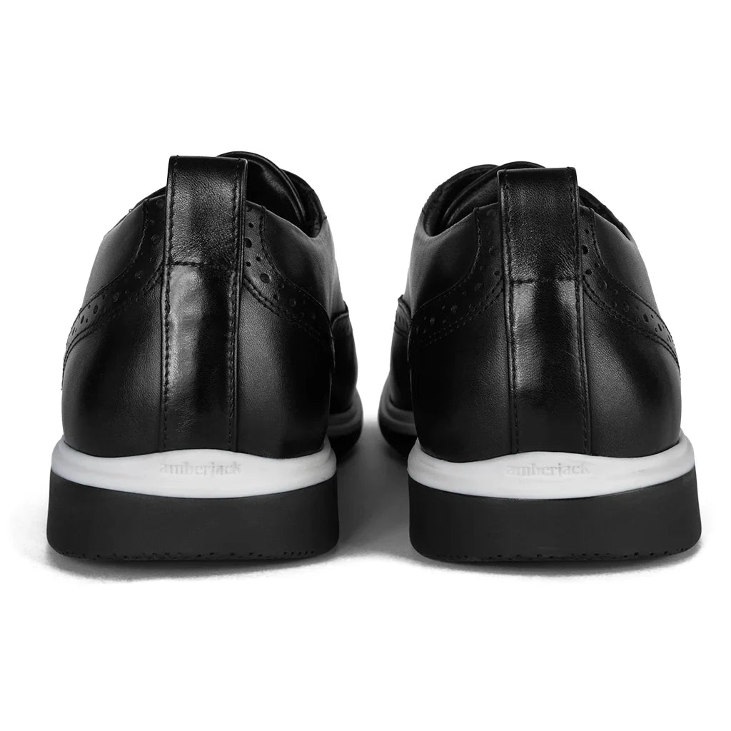 Black leather shoes with white soles on a white background