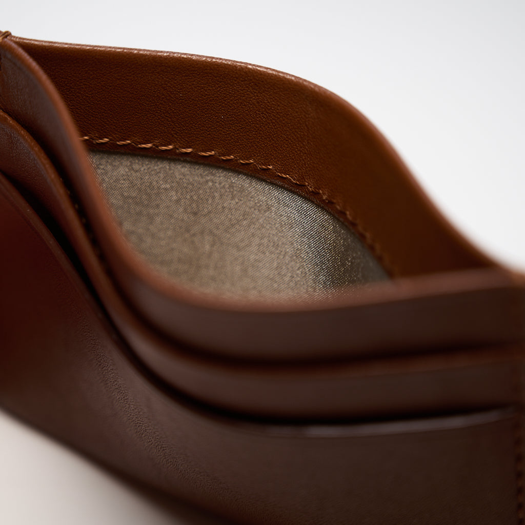 Close-up of a brown leather product with a textured interior.