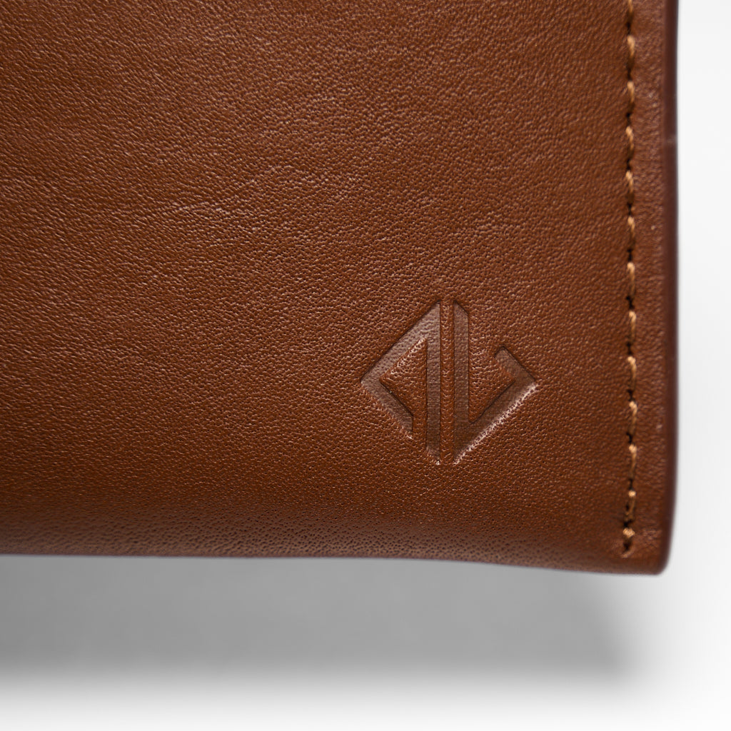 Close-up of a brown leather wallet with a brand logo on a white background