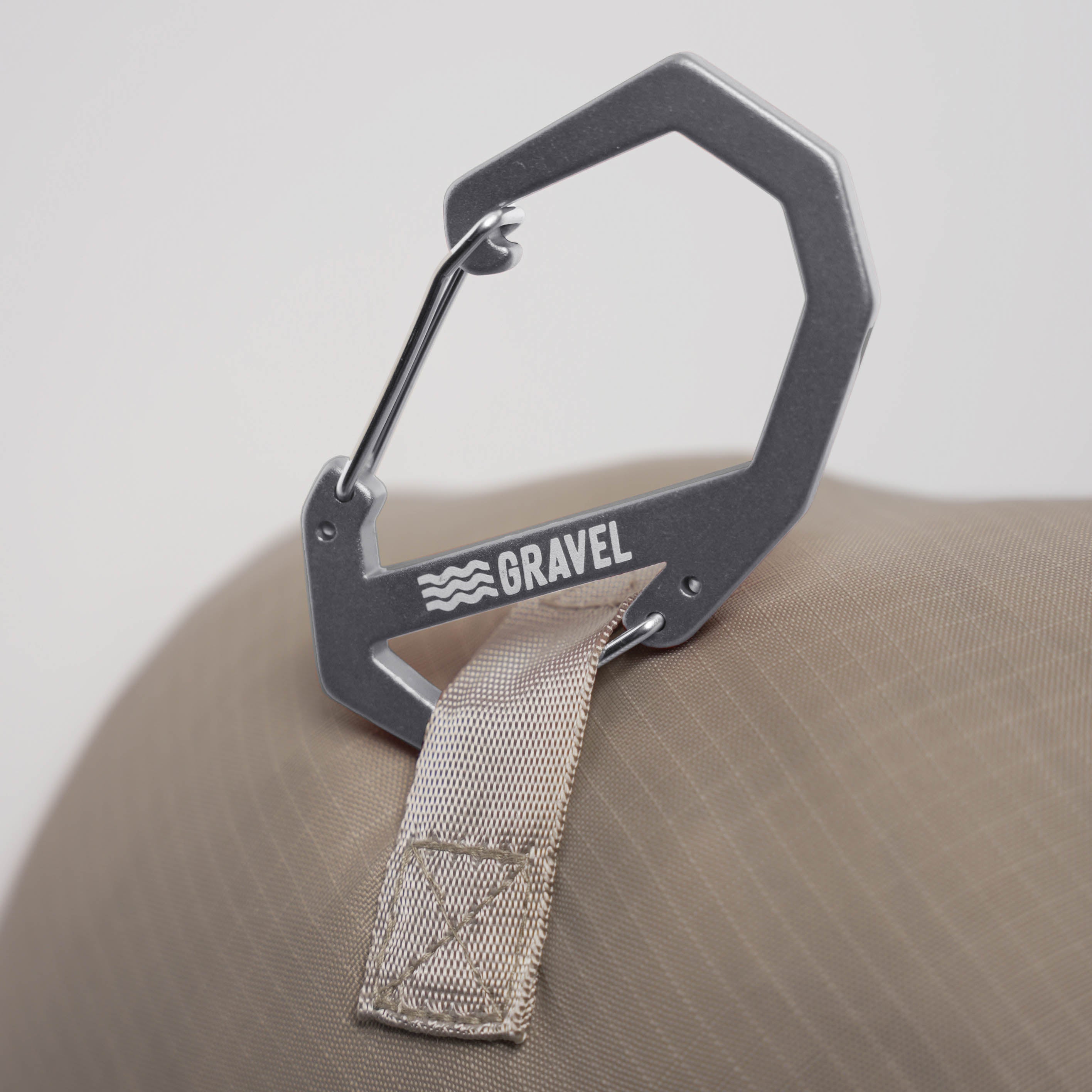 Metal carabiner with a strap on a beige surface