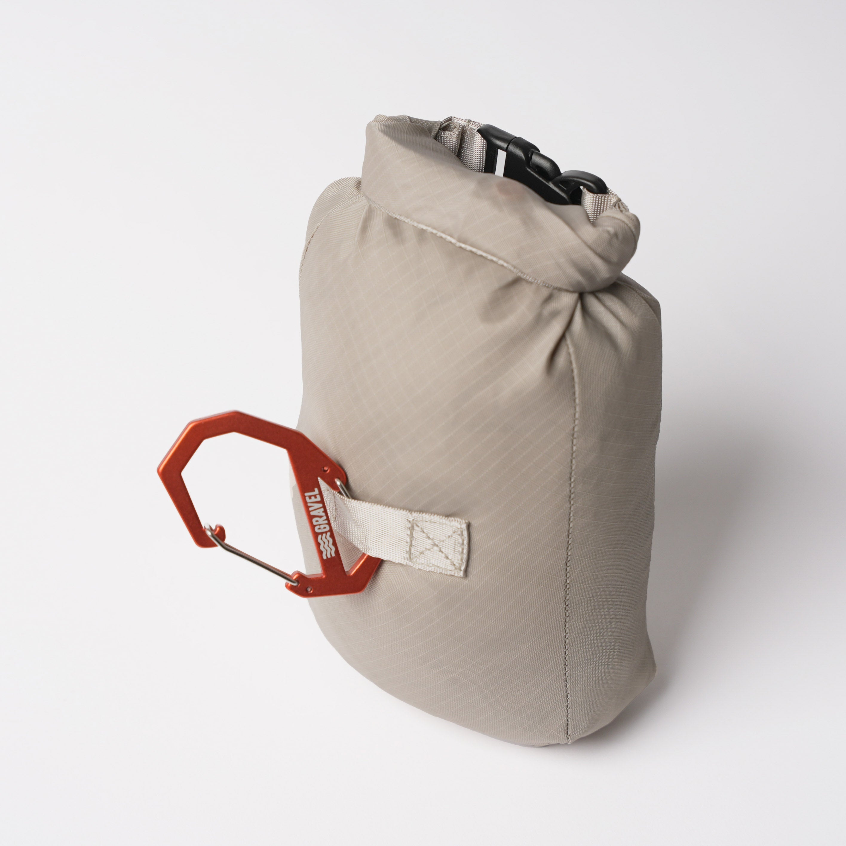 Beige dry bag with a red carabiner on a white background